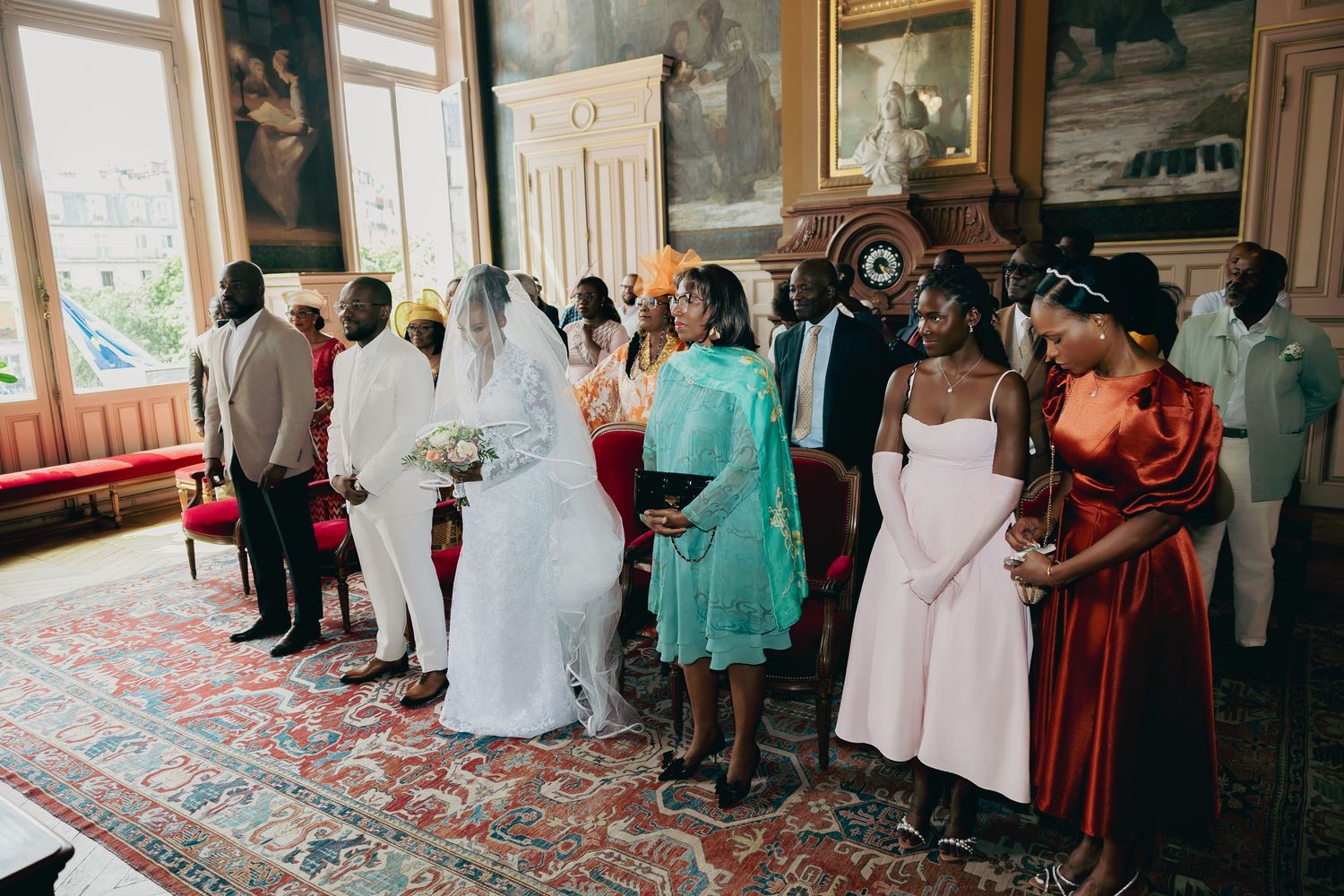 Wedding party gathers around bride and groom during intimate ceremony celebration.