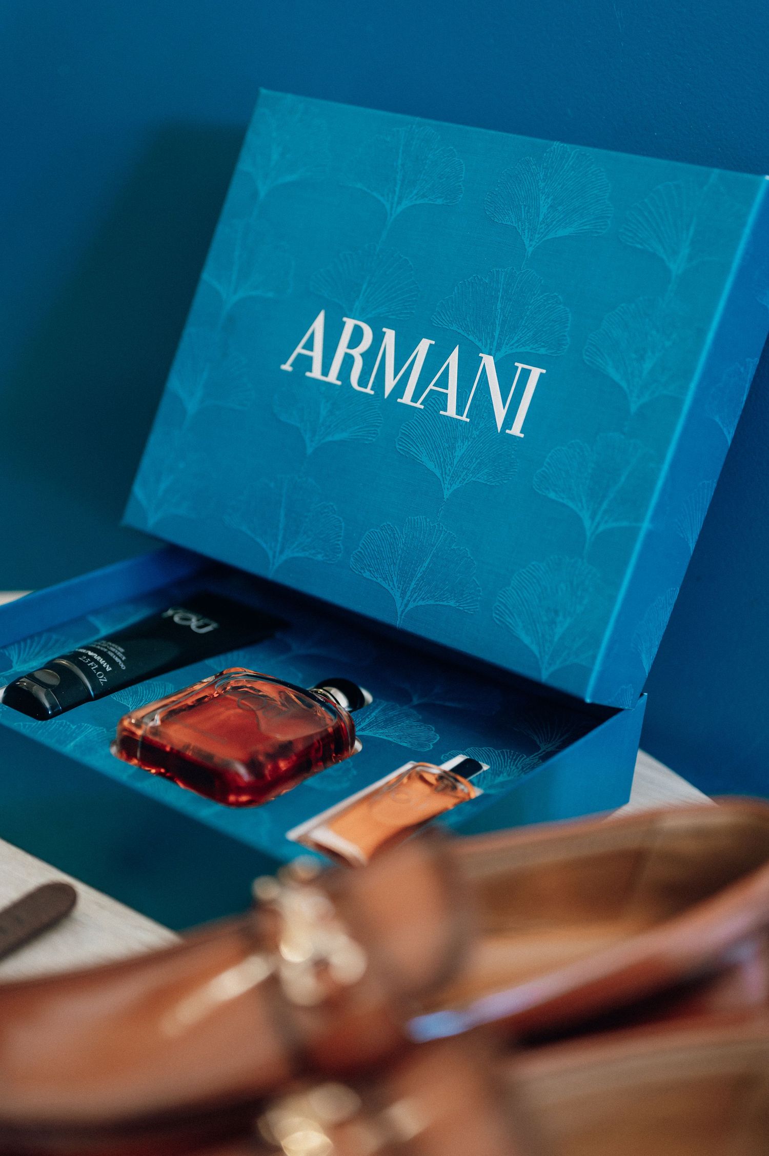 Armani luxury fragrance gift set in teal blue box with cologne and accessories.
