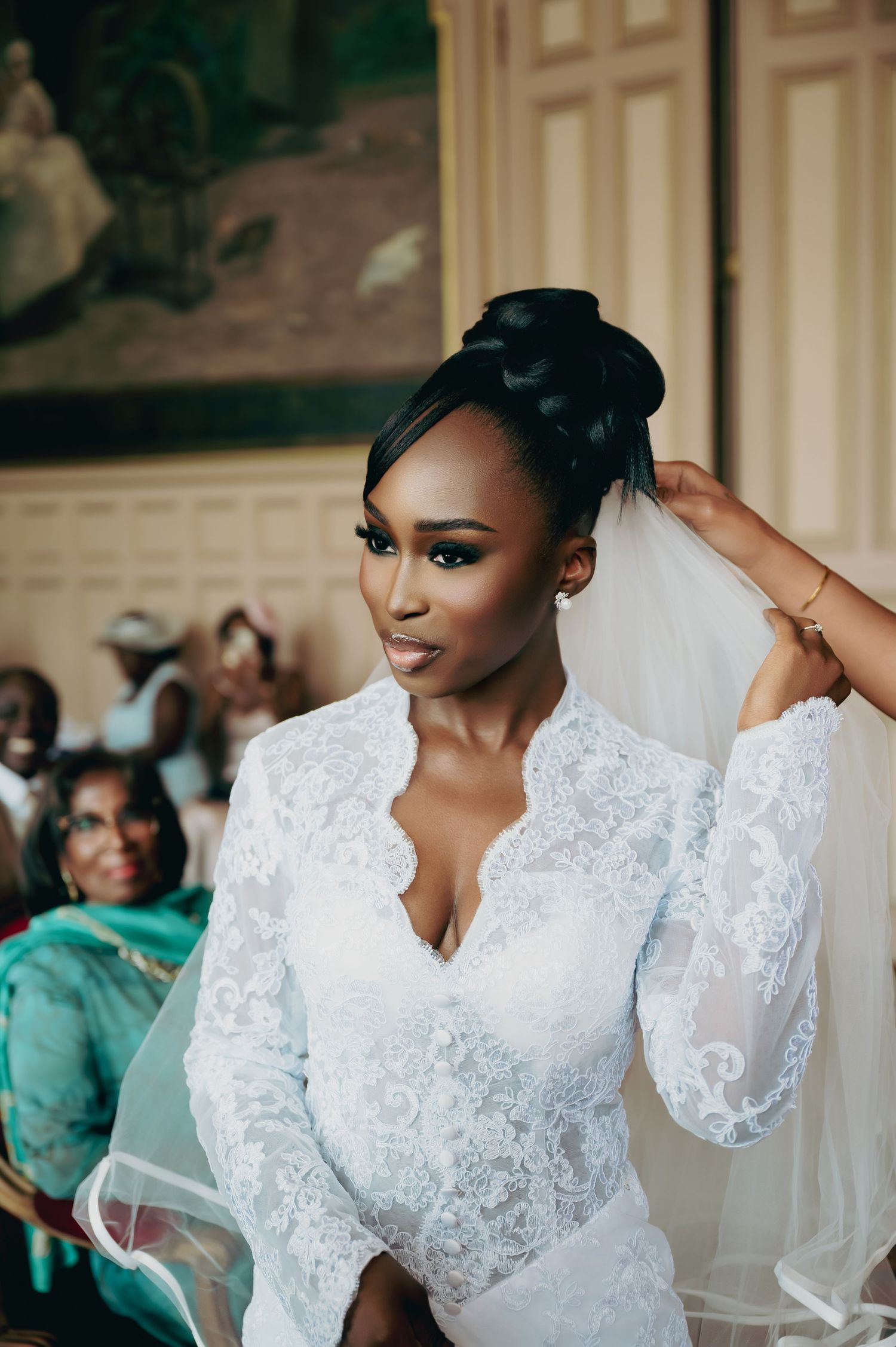A beautiful Black bride in a lace wedding gown with an elegant updo and veil.