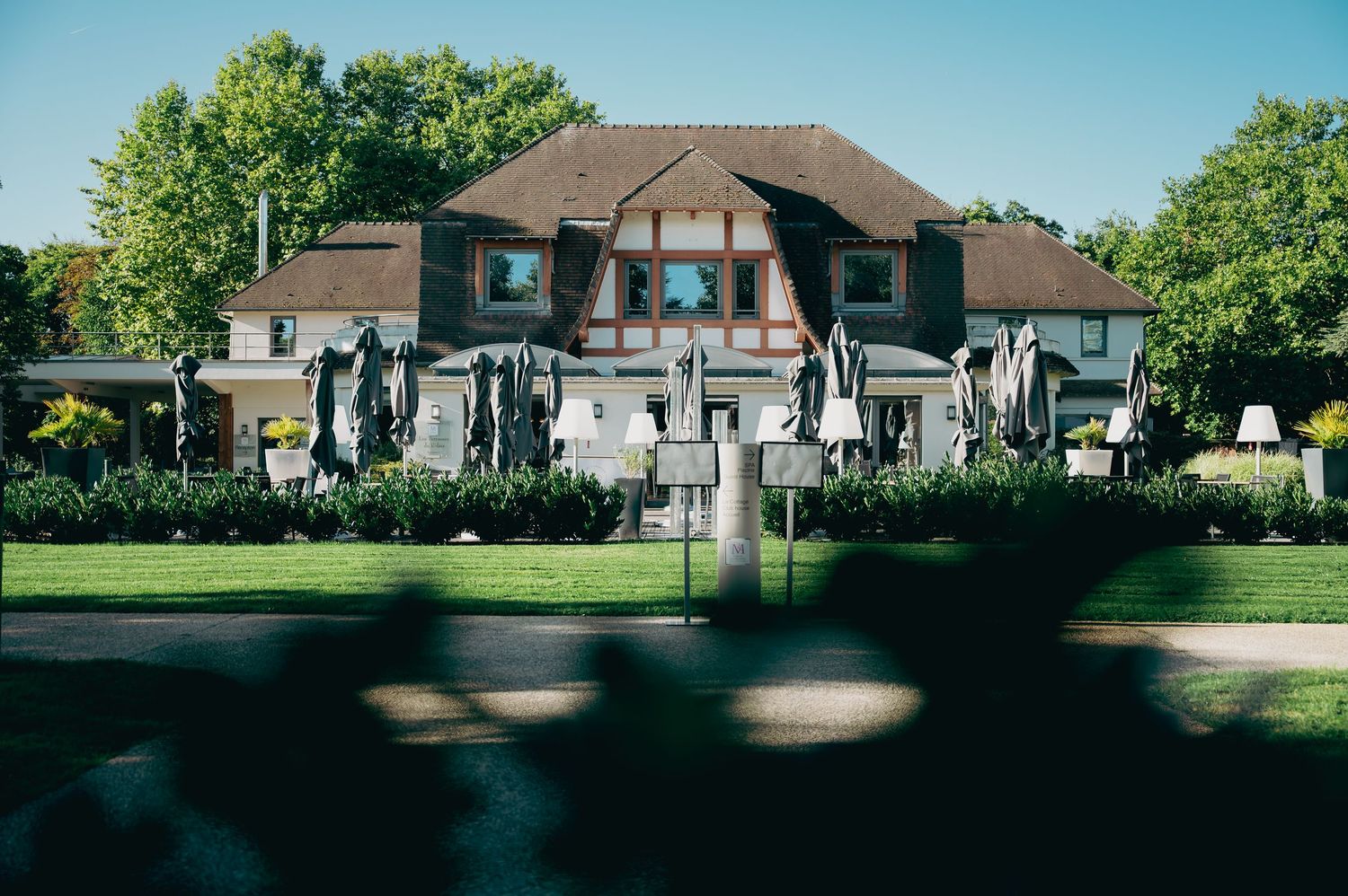 An elegant Tudor-style wedding venue surrounded by lush green trees and manicured gardens.