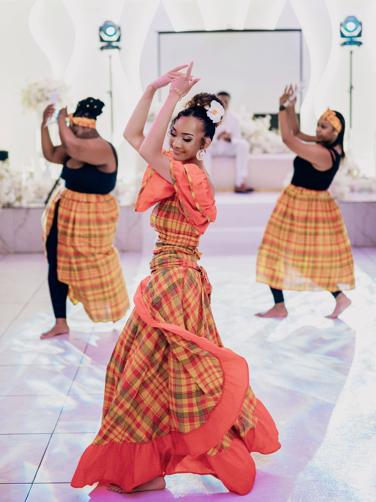 Bride in colorful madras skirt performing elegant traditional Caribbean dance.