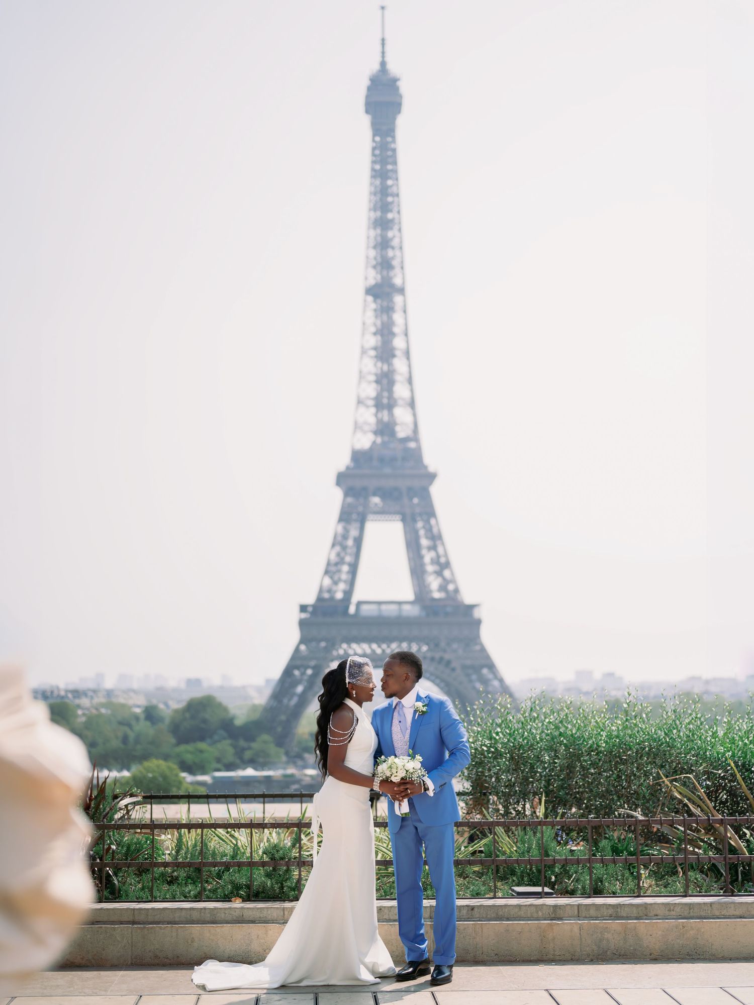 Bride and groom share romantic kiss in front of the Eiffel Tower in Paris.