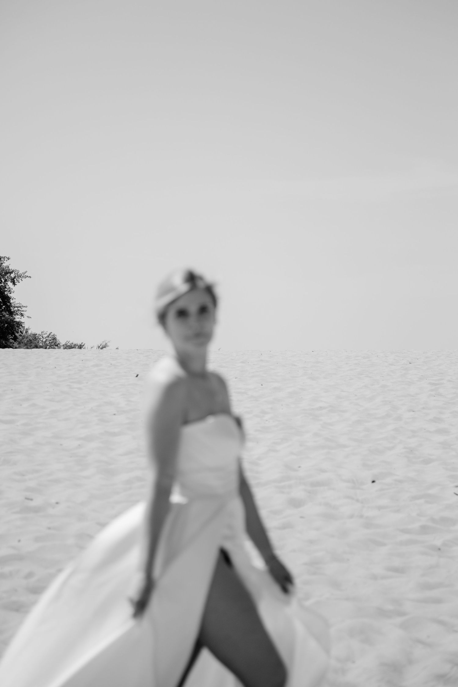 Artistic black and white series showing a bride walking on a bright, minimalist background.