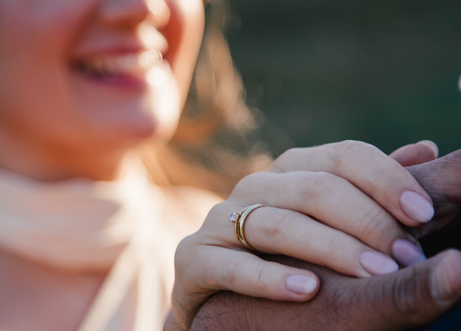 Close-up wedding photography focusing on hands and intimate gestures in natural light.