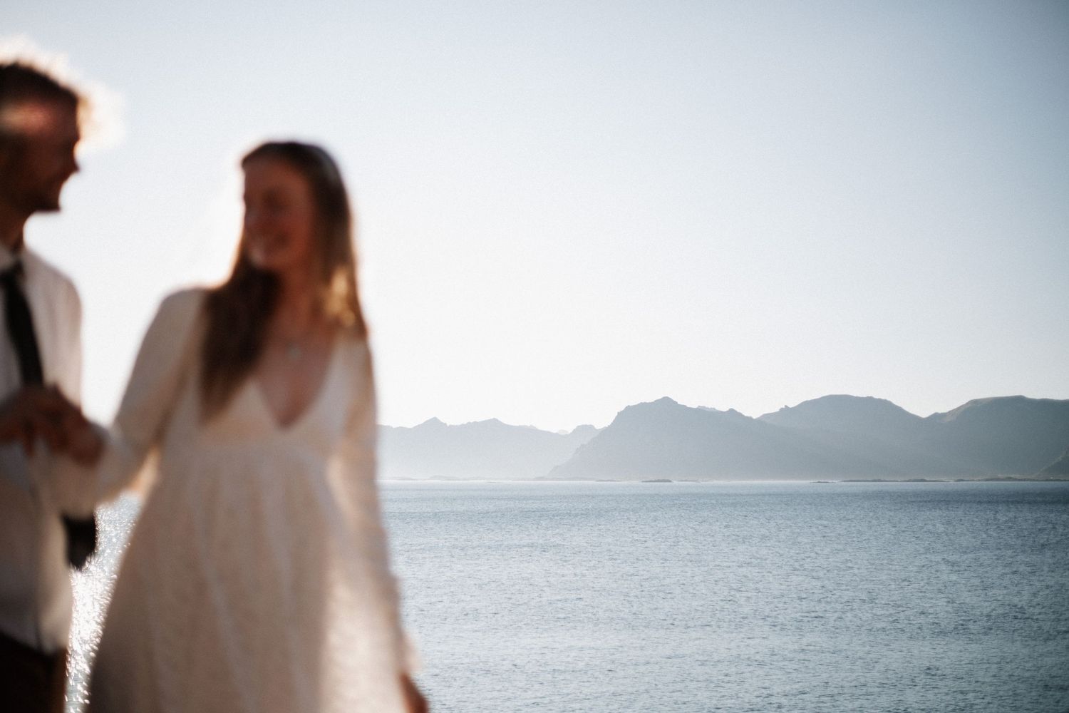Scenic coastal mountain view with figure in white dress.