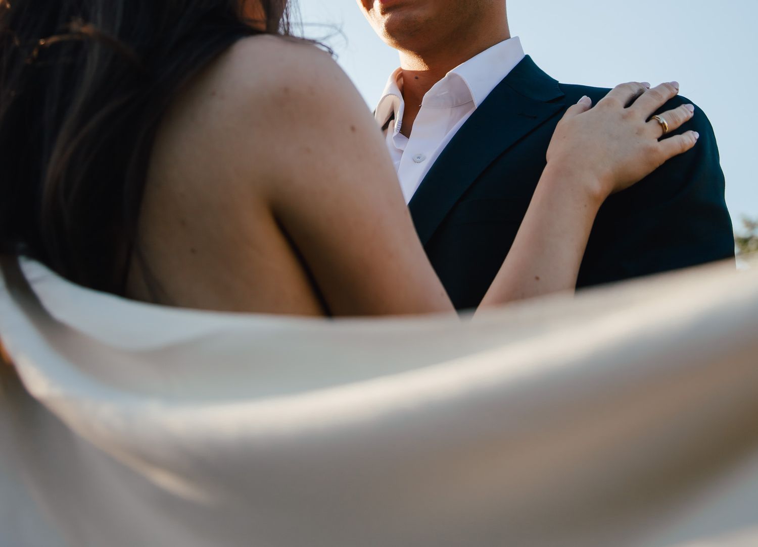 Intimate wedding couple portrait showing tender embrace against blurred background.