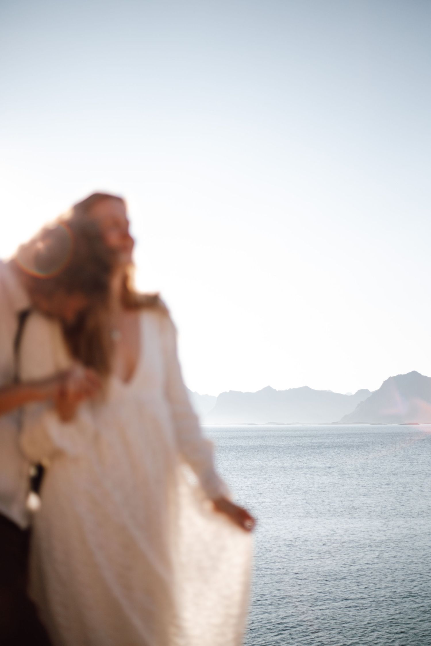 Dreamy, out-of-focus wedding photos with ocean and mountain backdrop.