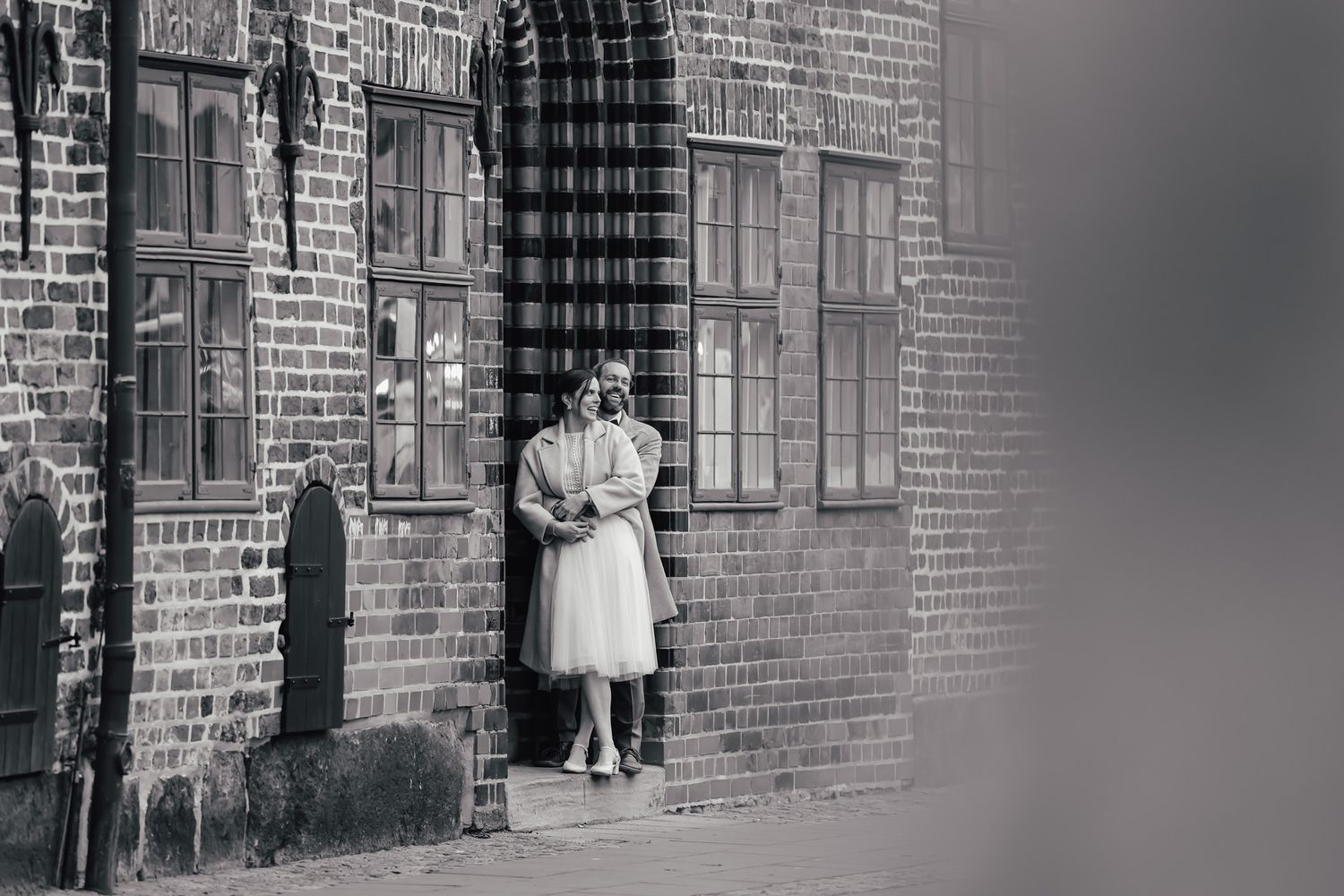 Vintage style black and white photograph against brick wall exterior.