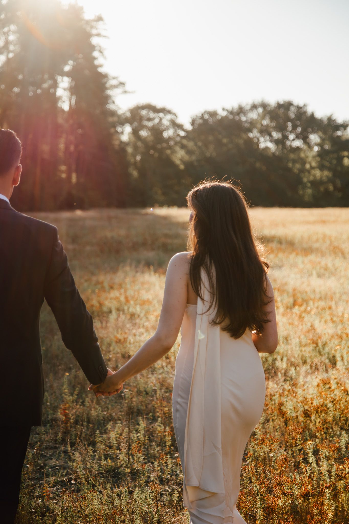 Golden hour wedding photos in a wildflower field with dramatic sunlight.