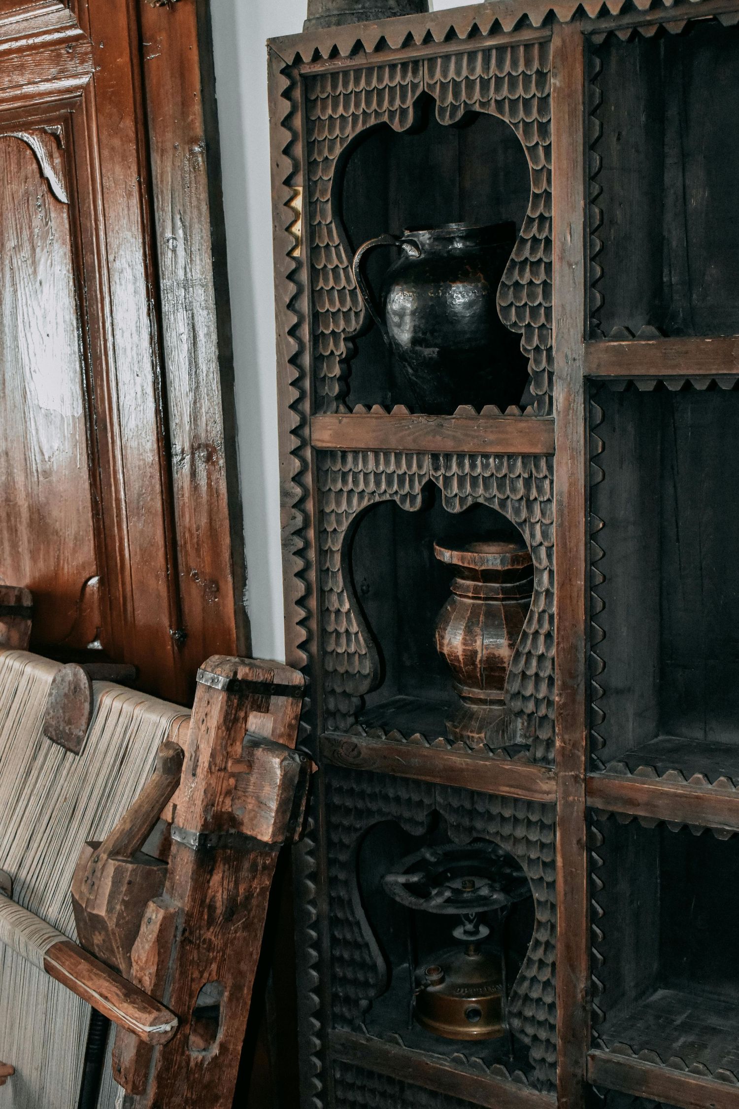 Dark wooden shelving with intricate Victorian-style carved details and decorative trim.