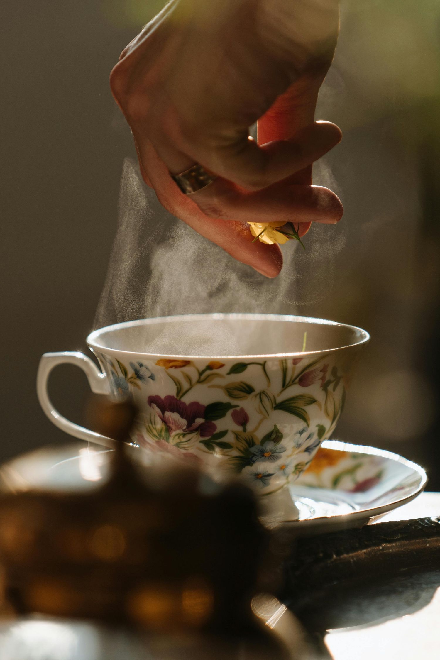 Steam rising from decorative porcelain teacup with floral pattern.