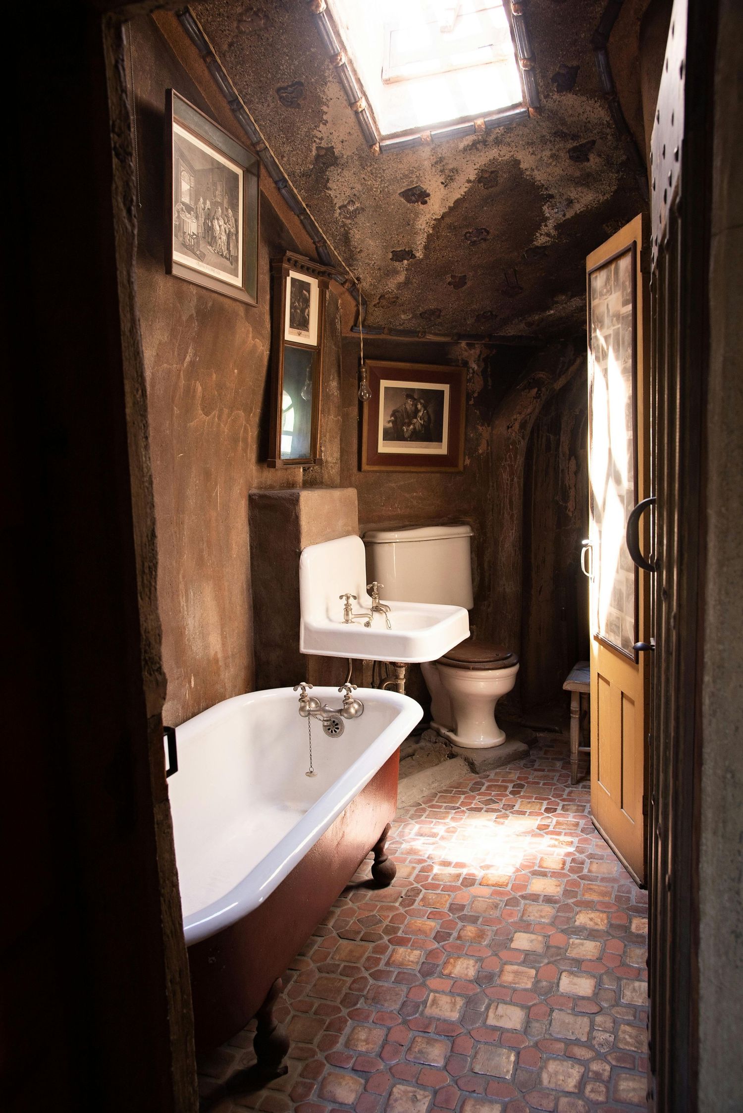 Vintage bathroom with clawfoot tub, tiled floor, and natural light streaming through window.