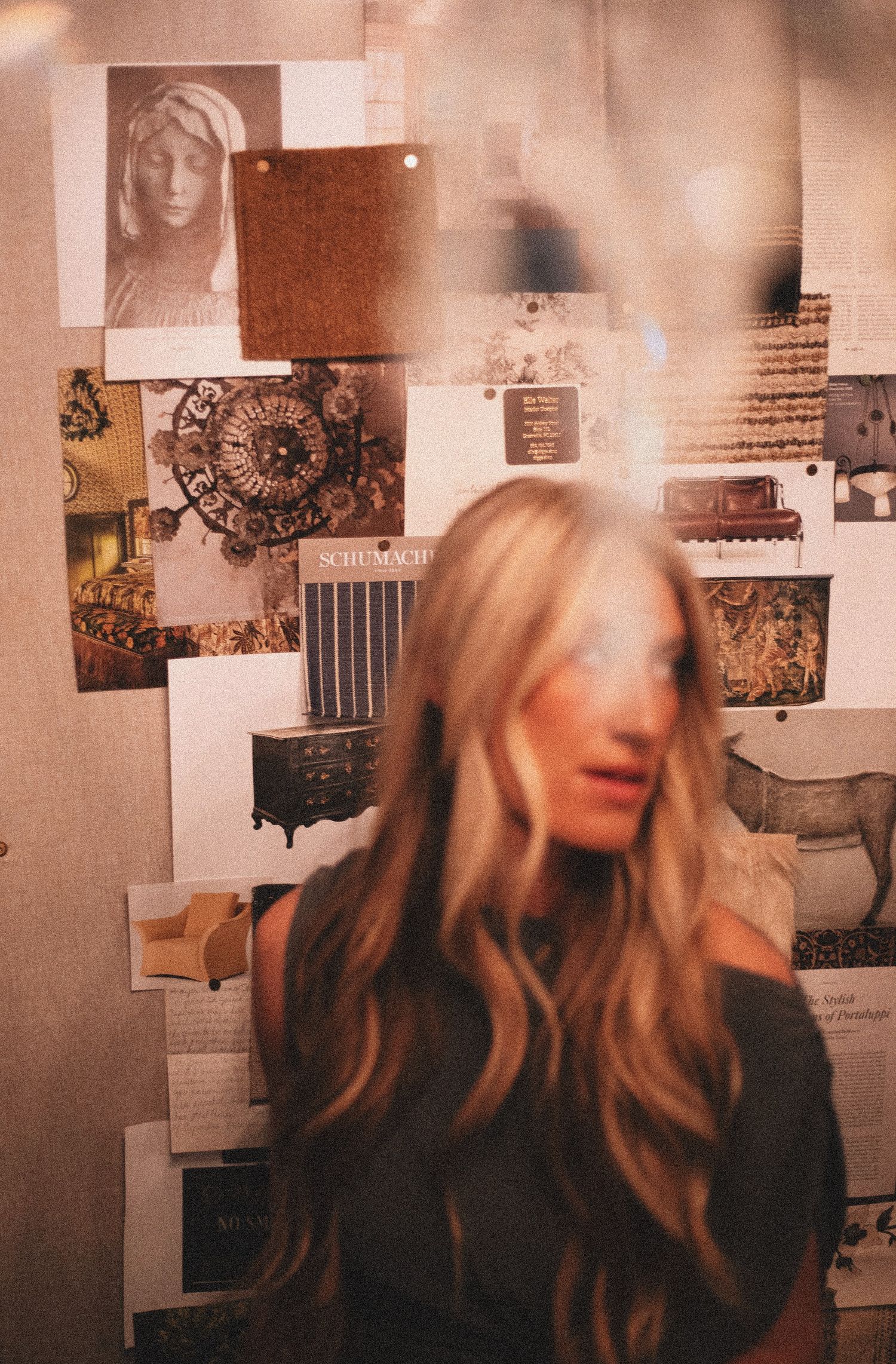 Blonde woman stands before vintage-style interior design mood board with antique decor images.