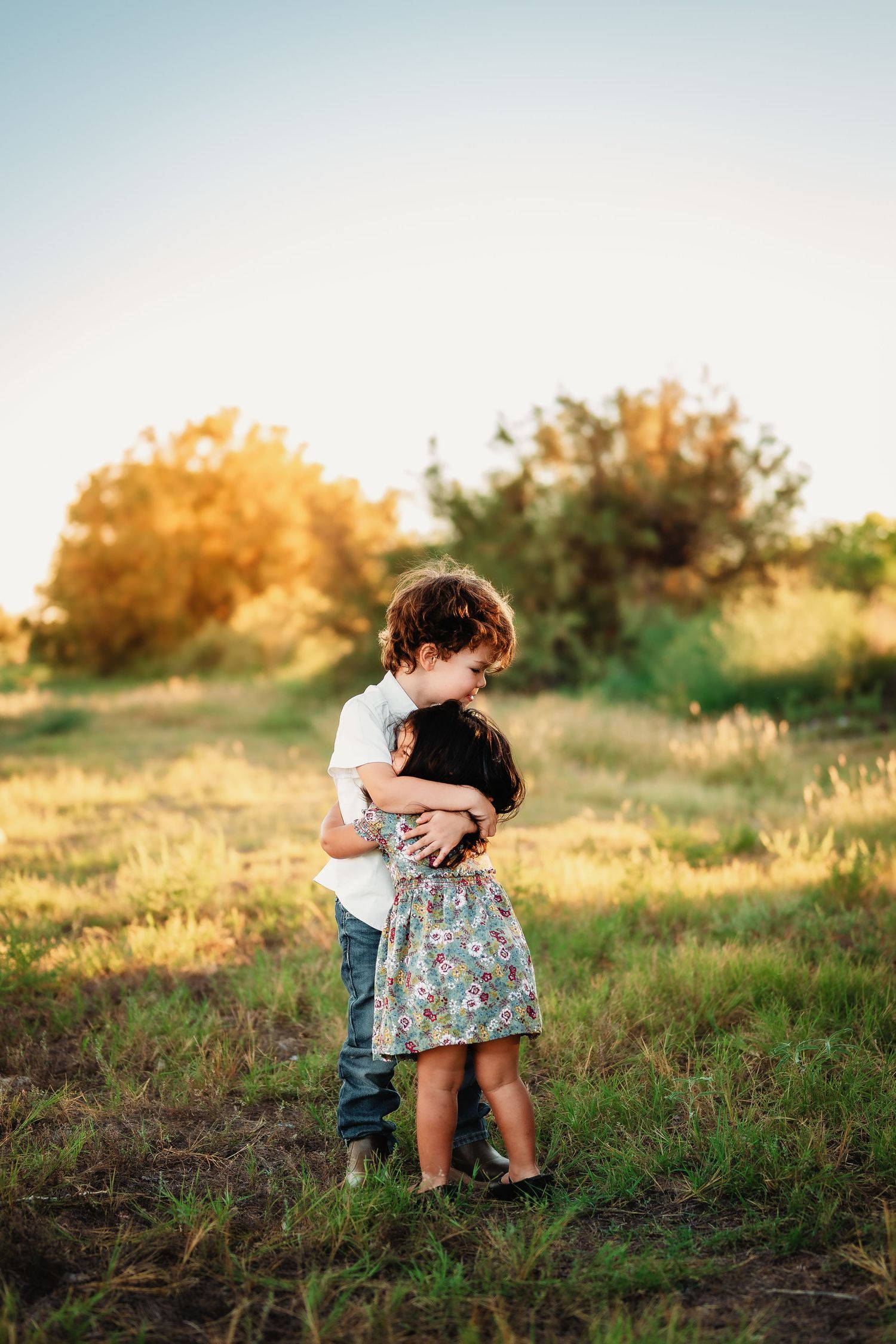 Children playing together in a sunlit field during golden hour.