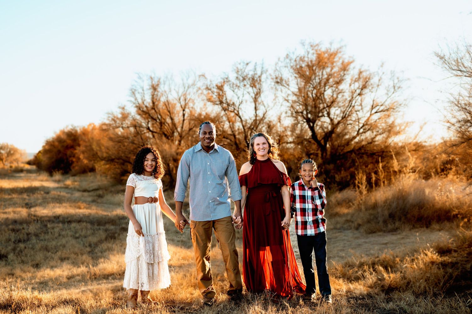 Group photo session at sunset in a desert landscape with coordinated outfits.
