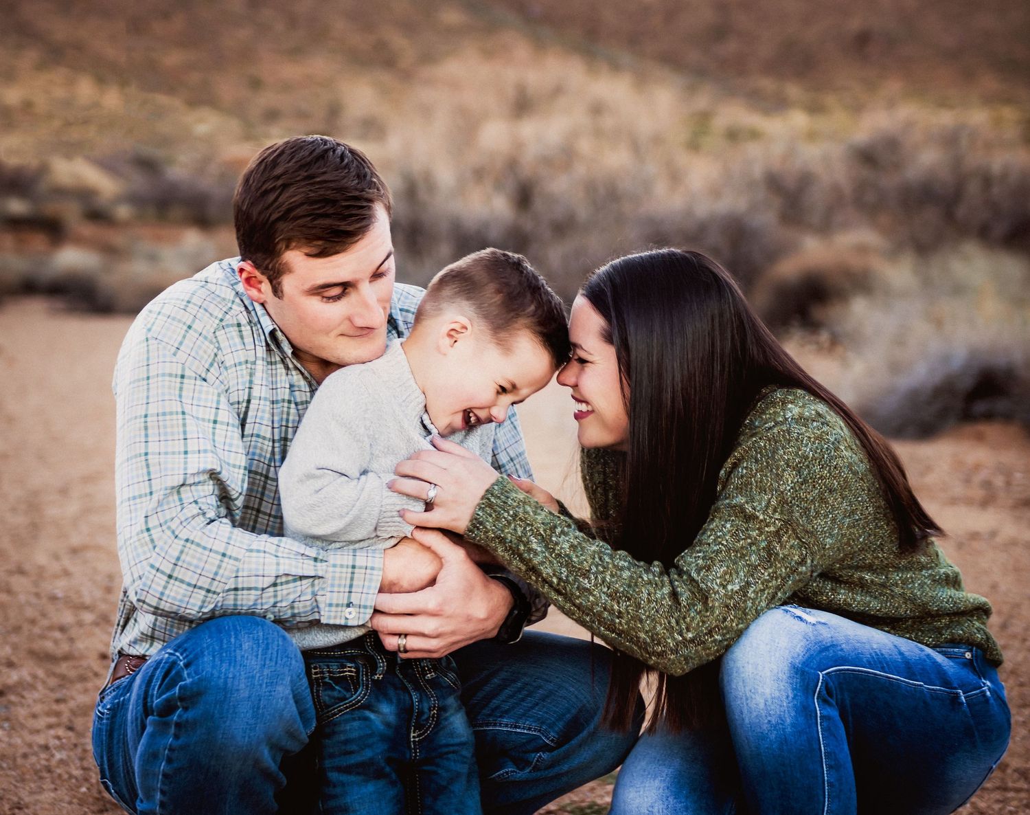 Intimate family moment captured during outdoor desert photoshoot.