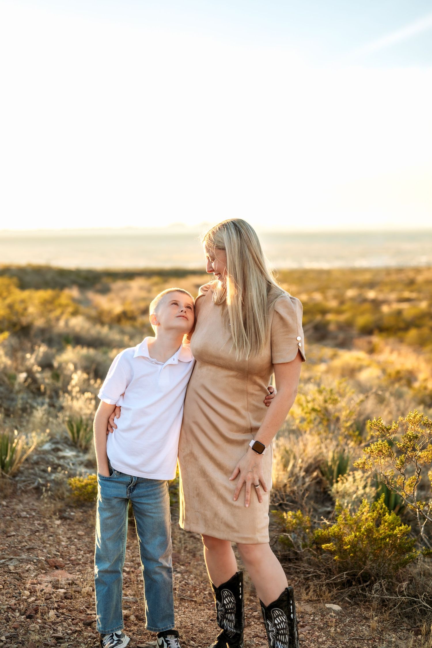 Desert landscape family photoshoot during golden hour with brush and mountains in background.