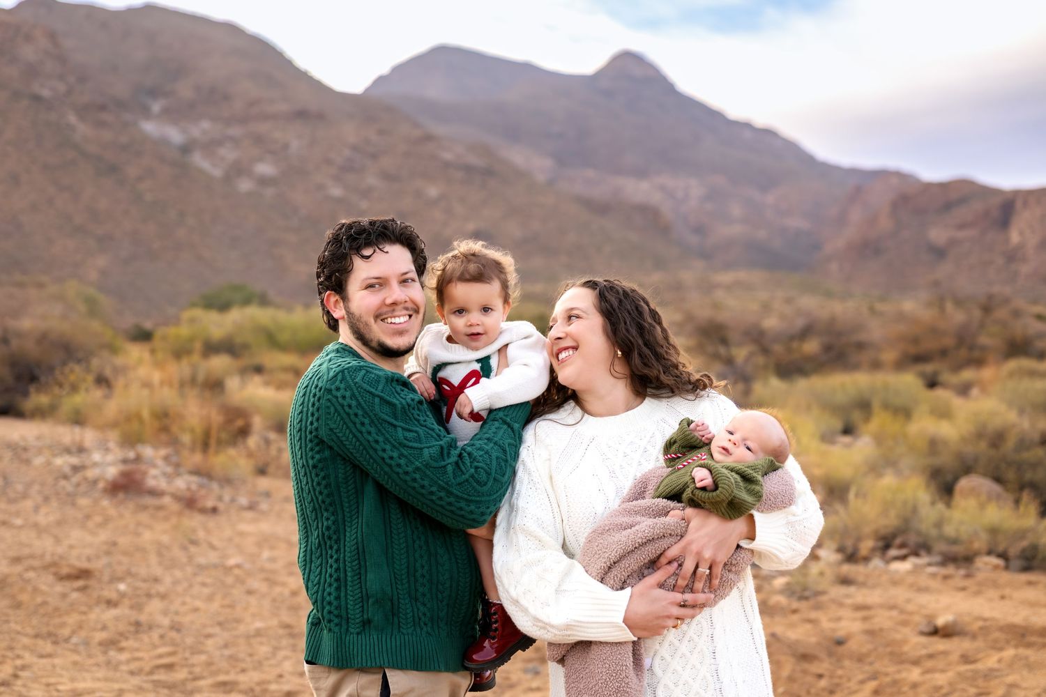 A family shares joyful moments together in front of desert mountains.
