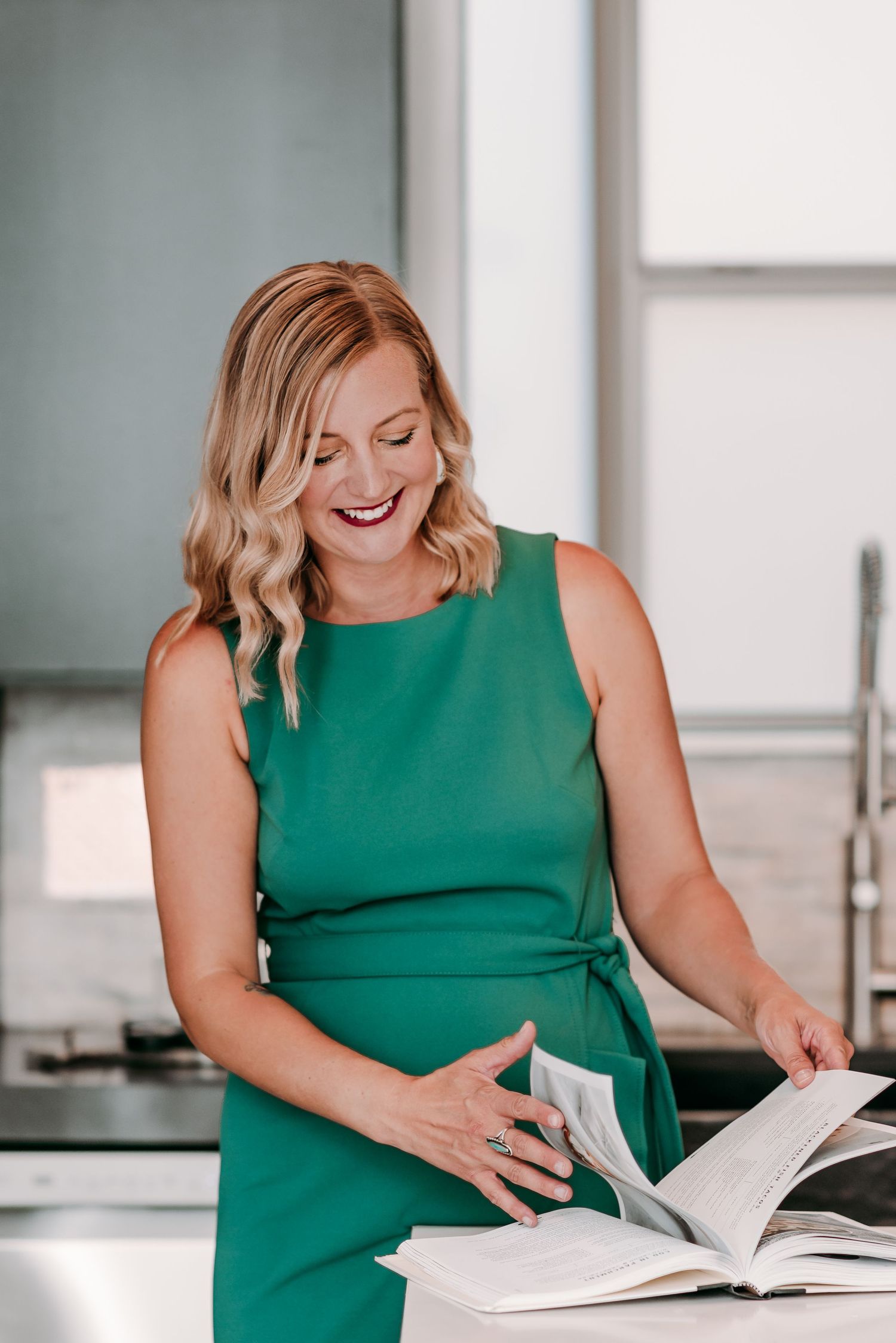 A series of photos showing a person in a green sleeveless dress reading and laughing while looking at a book.