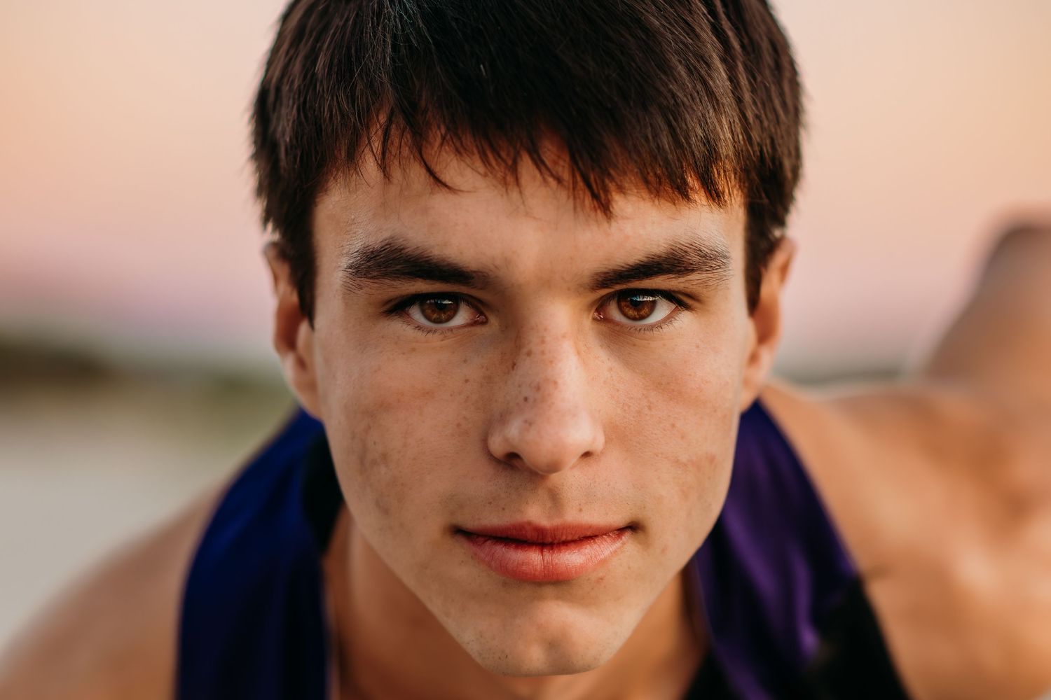 Close up portrait of a runner in ready stance against pink sunset sky.