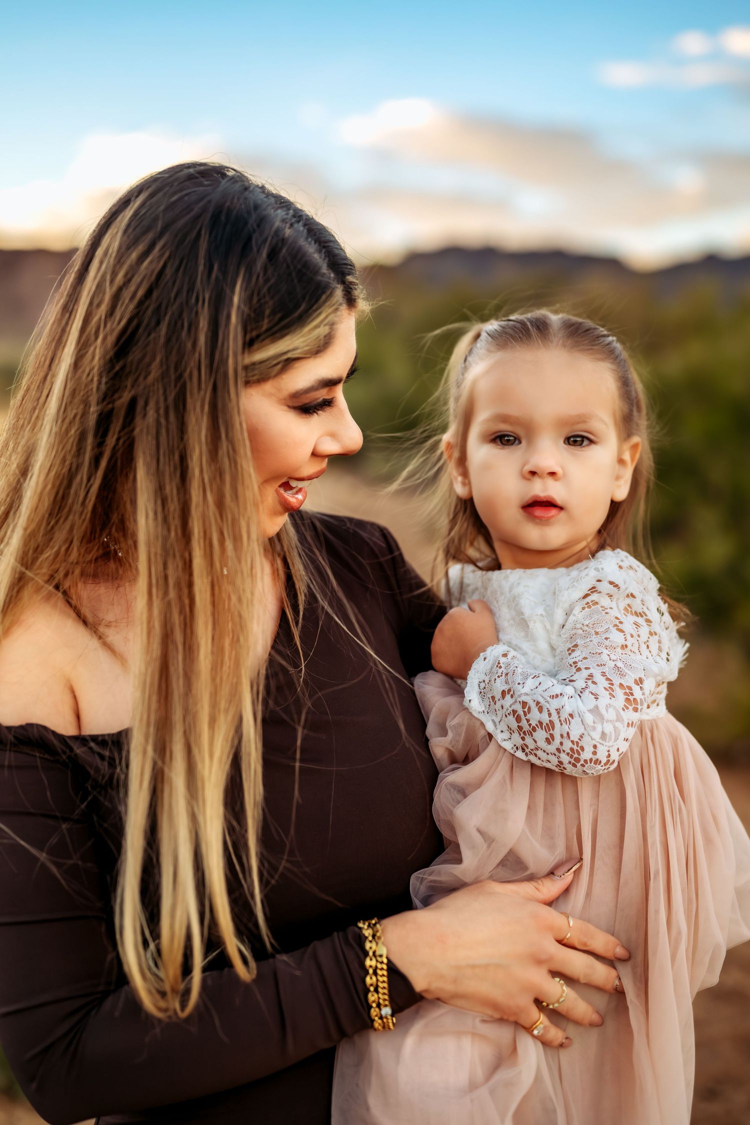 A tender moment captured between parent and child against a sunset mountain backdrop.