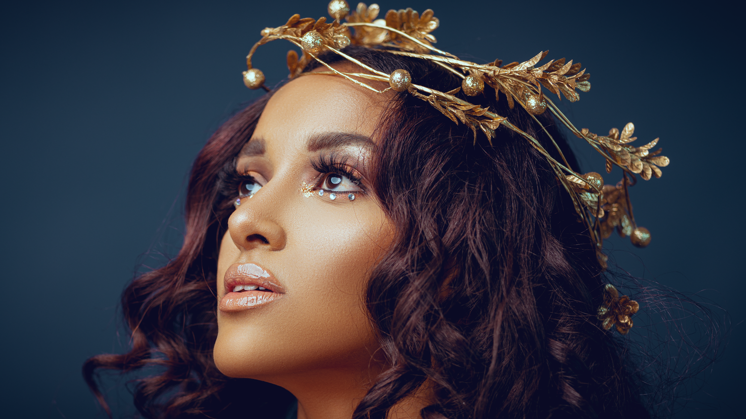 Elegant portrait with gold crown and delicate butterfly accents.
