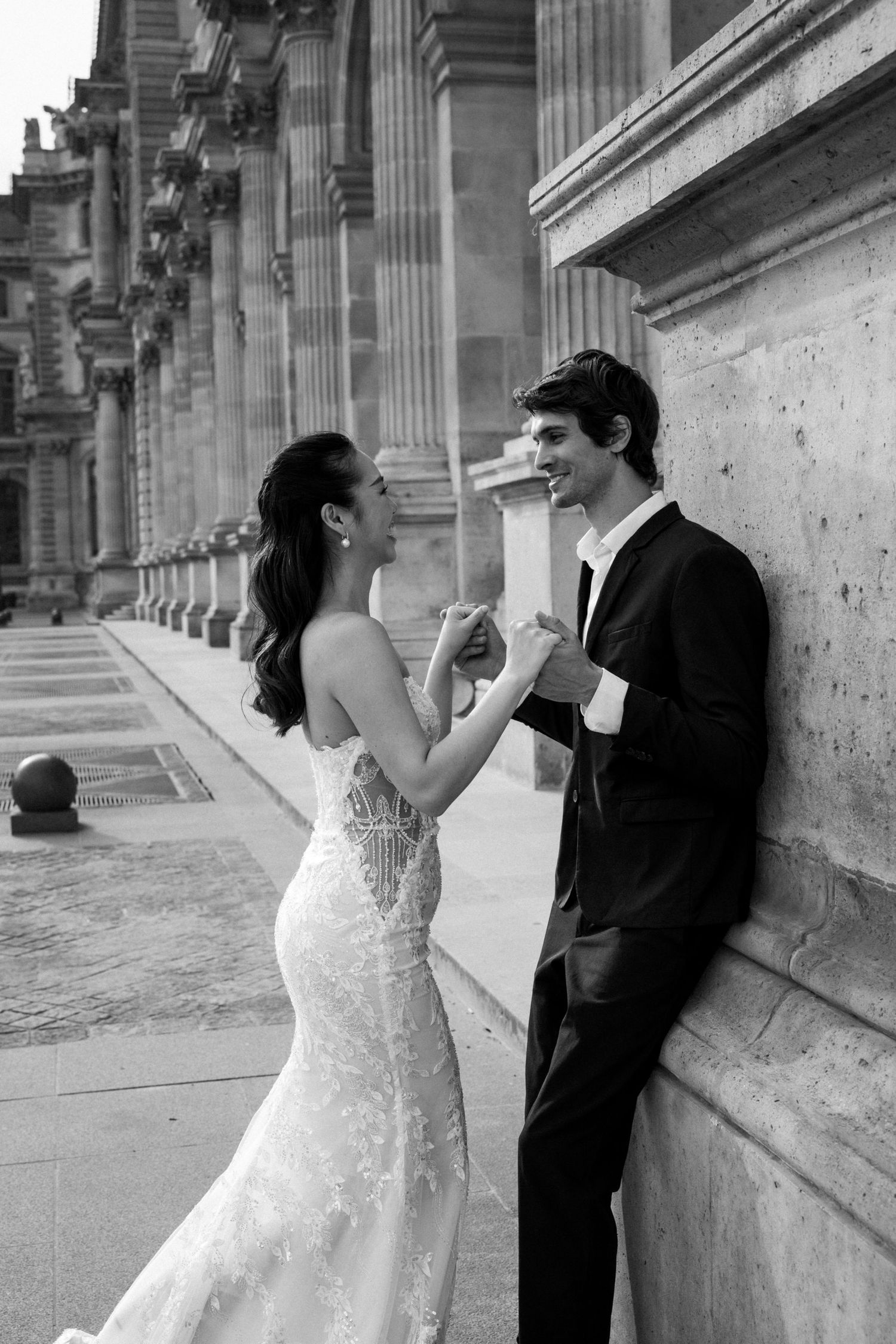 A romantic black and white wedding photo sequence showing a couple sharing intimate moments against a stone wall.