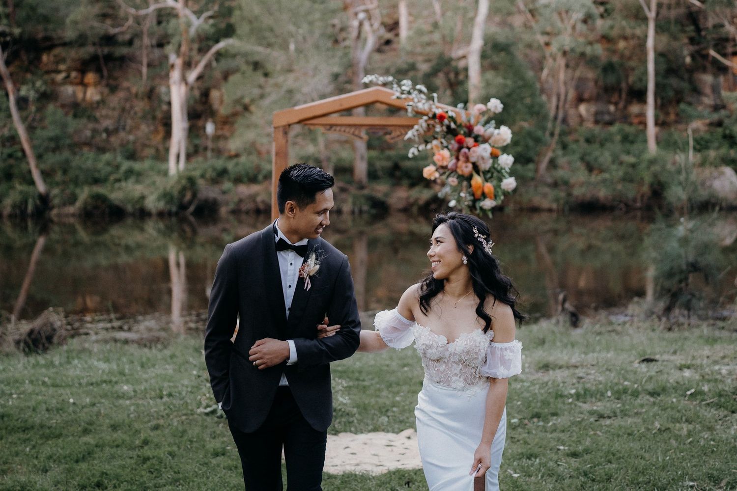 Couple shares playful moments in formal attire against natural backdrop.