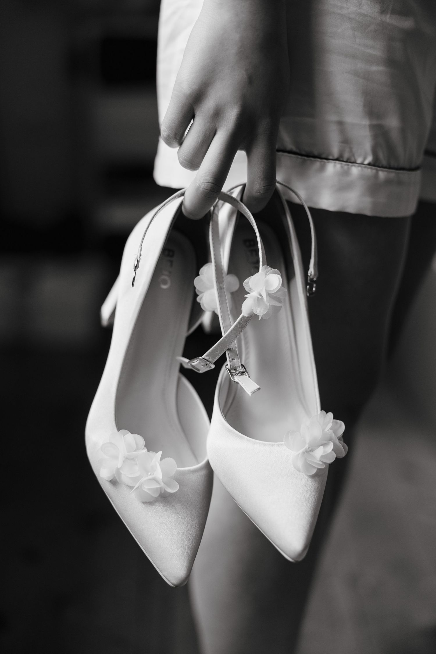 Delicate white bridal shoes with floral embellishments in black and white.