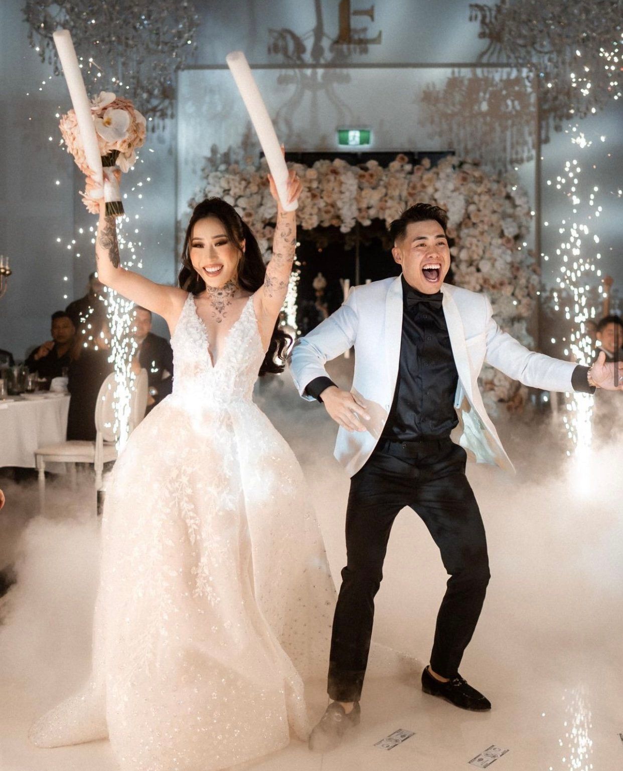 Wedding celebration with sparklers and fog effects on dance floor.