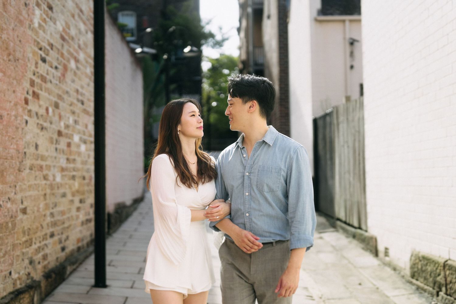 A couple shares romantic moments in a quaint alleyway.