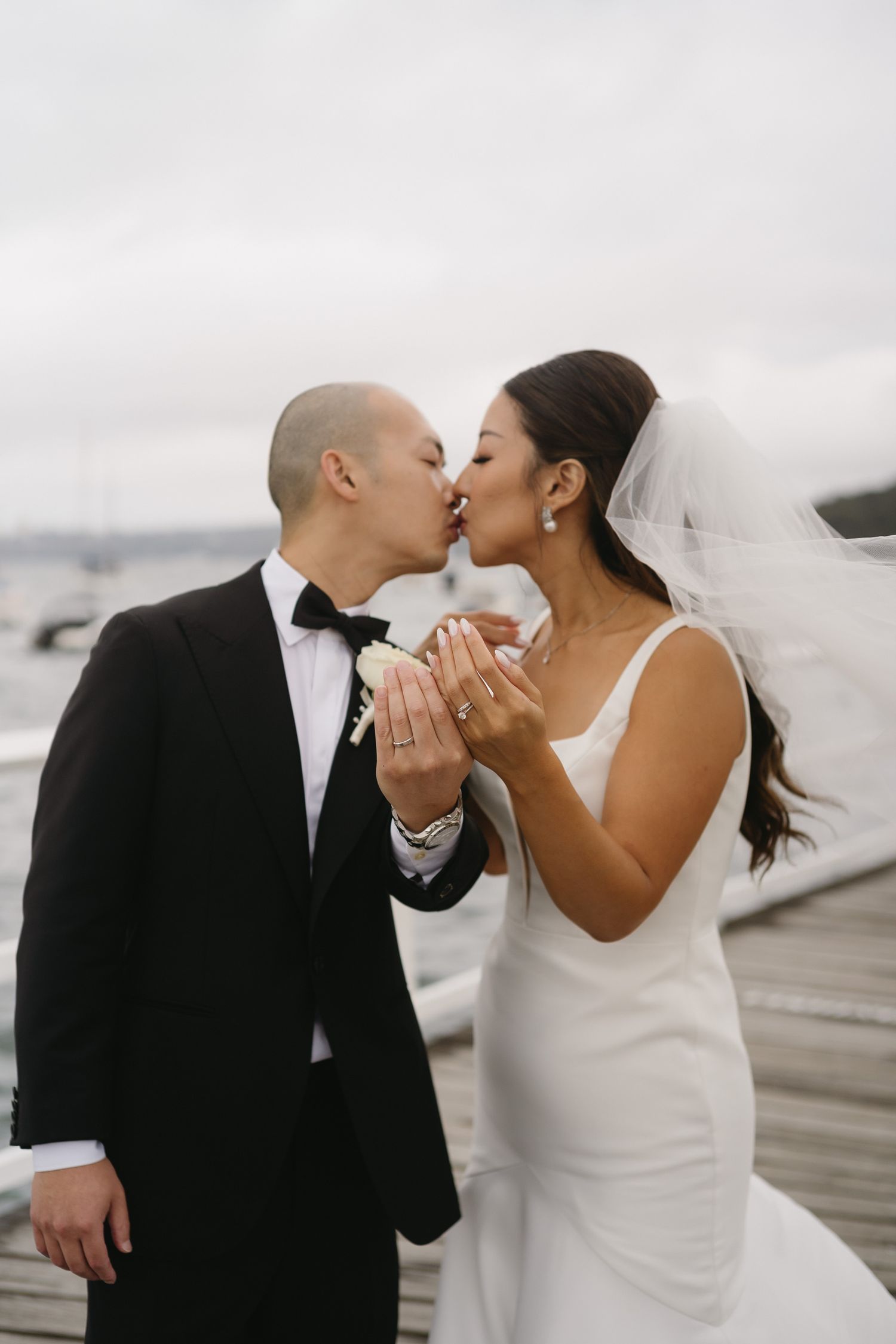 Romantic wedding couple sharing intimate moments by the waterfront.