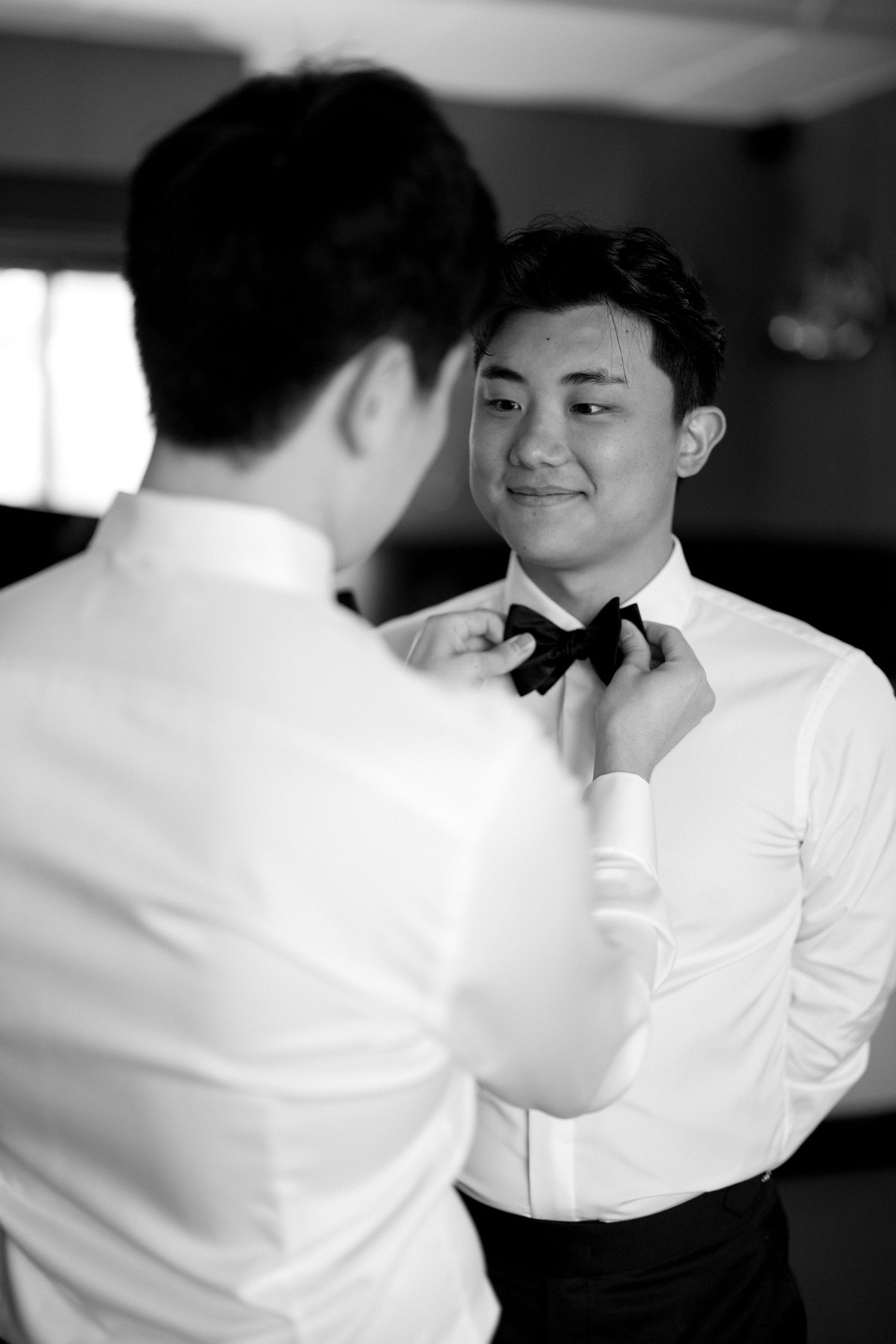 A sequence of black and white photos showing someone in a white button-up shirt adjusting their collar.