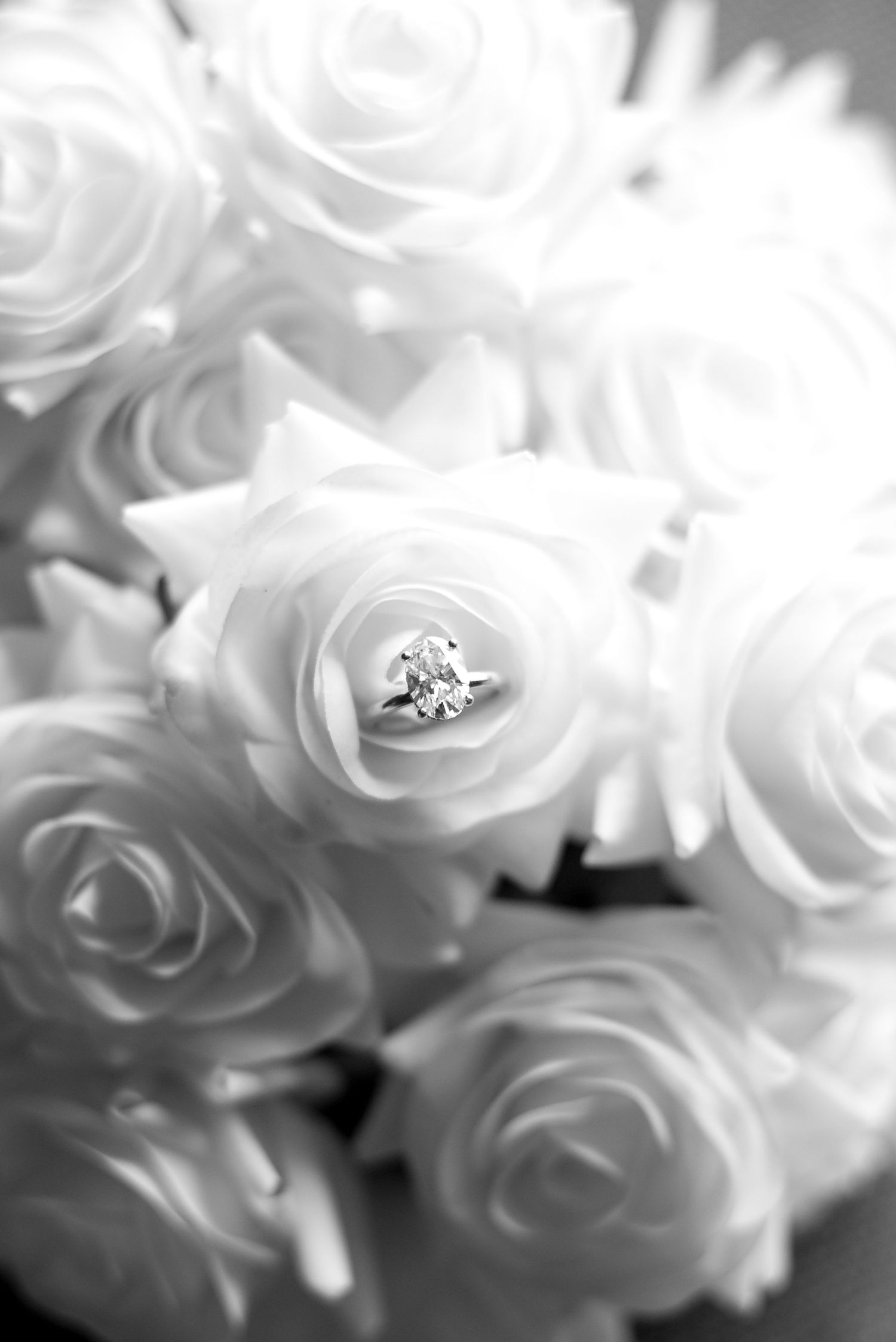 Close-up of delicate white roses with sparkling diamond accents nestled among the soft petals.