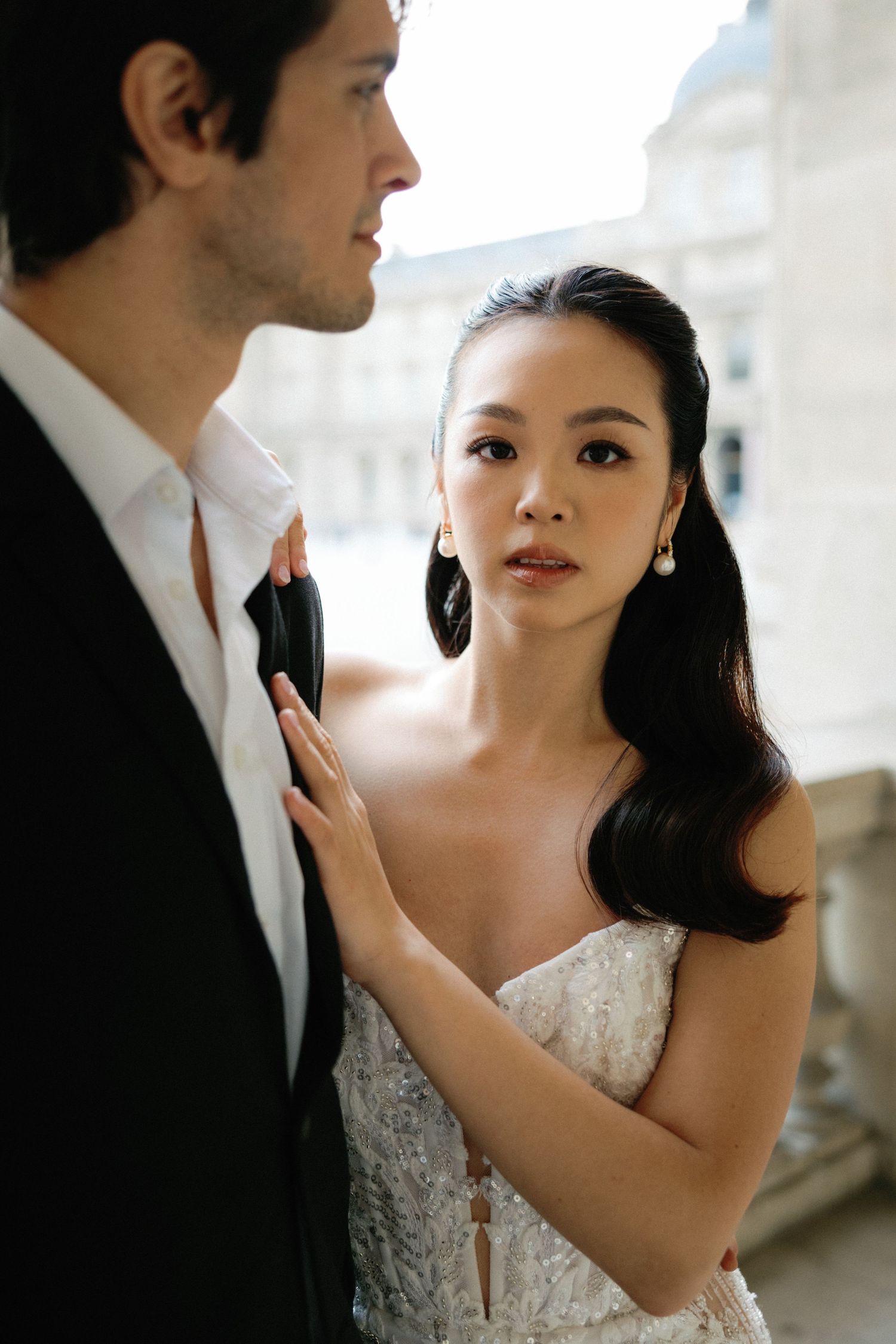 Intimate wedding portraits showing tender moments between a couple against a light-colored wall.