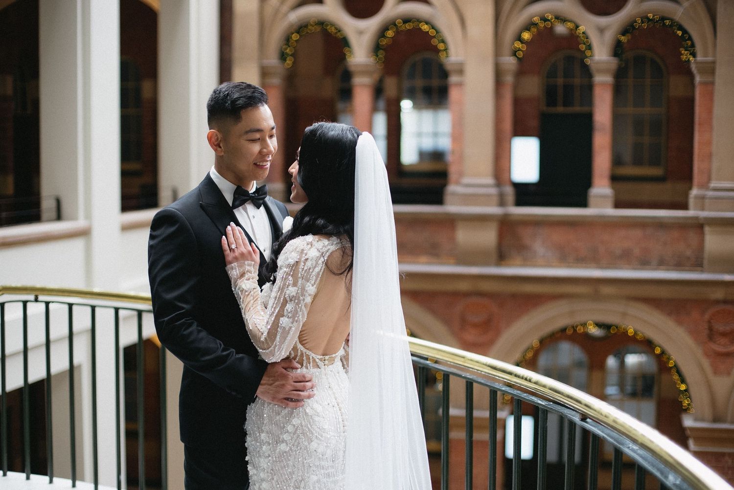 Wedding couple sharing romantic moments against historic building backdrop.