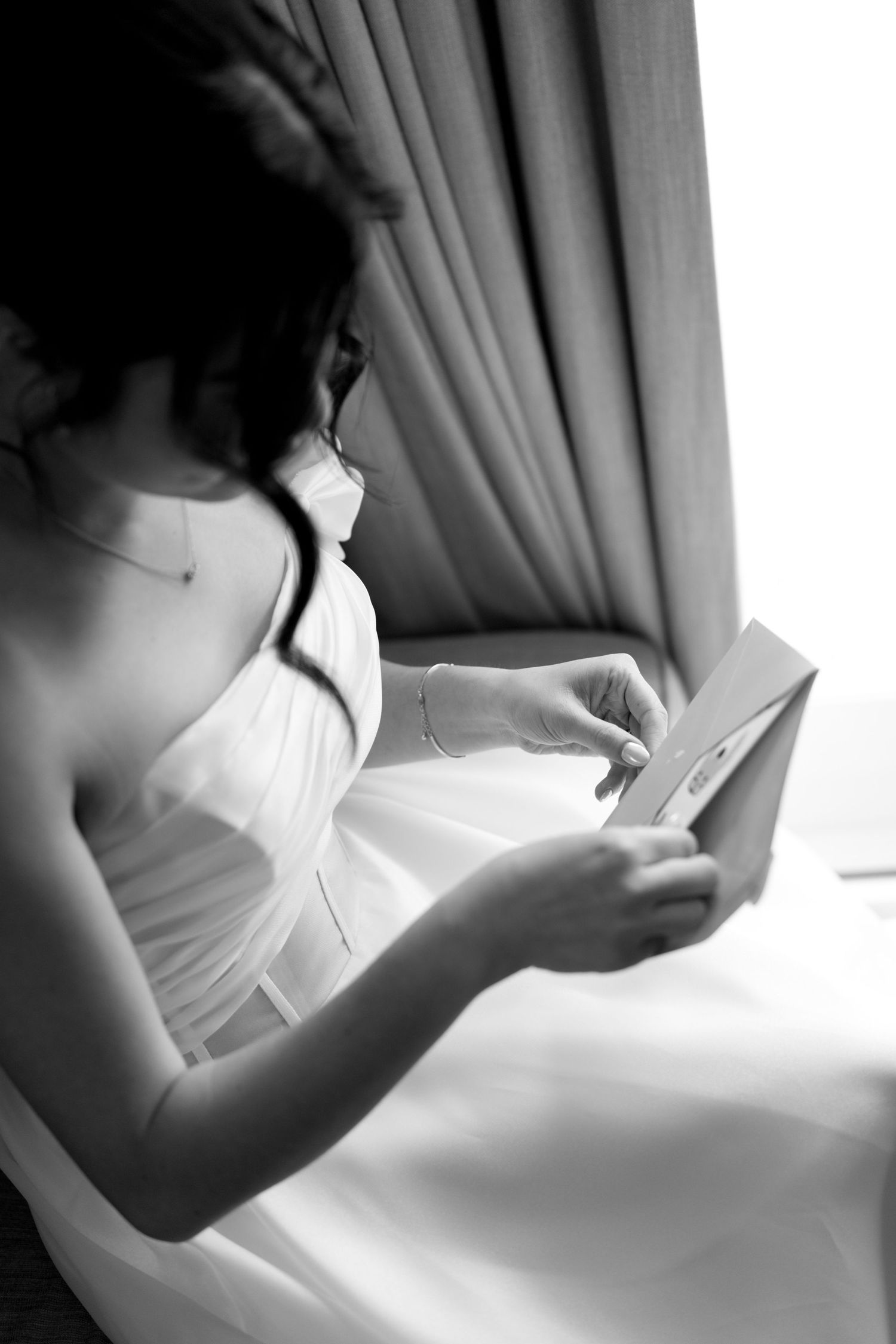 A series of black and white photos showing hands delicately adjusting curtain fabric in different positions.