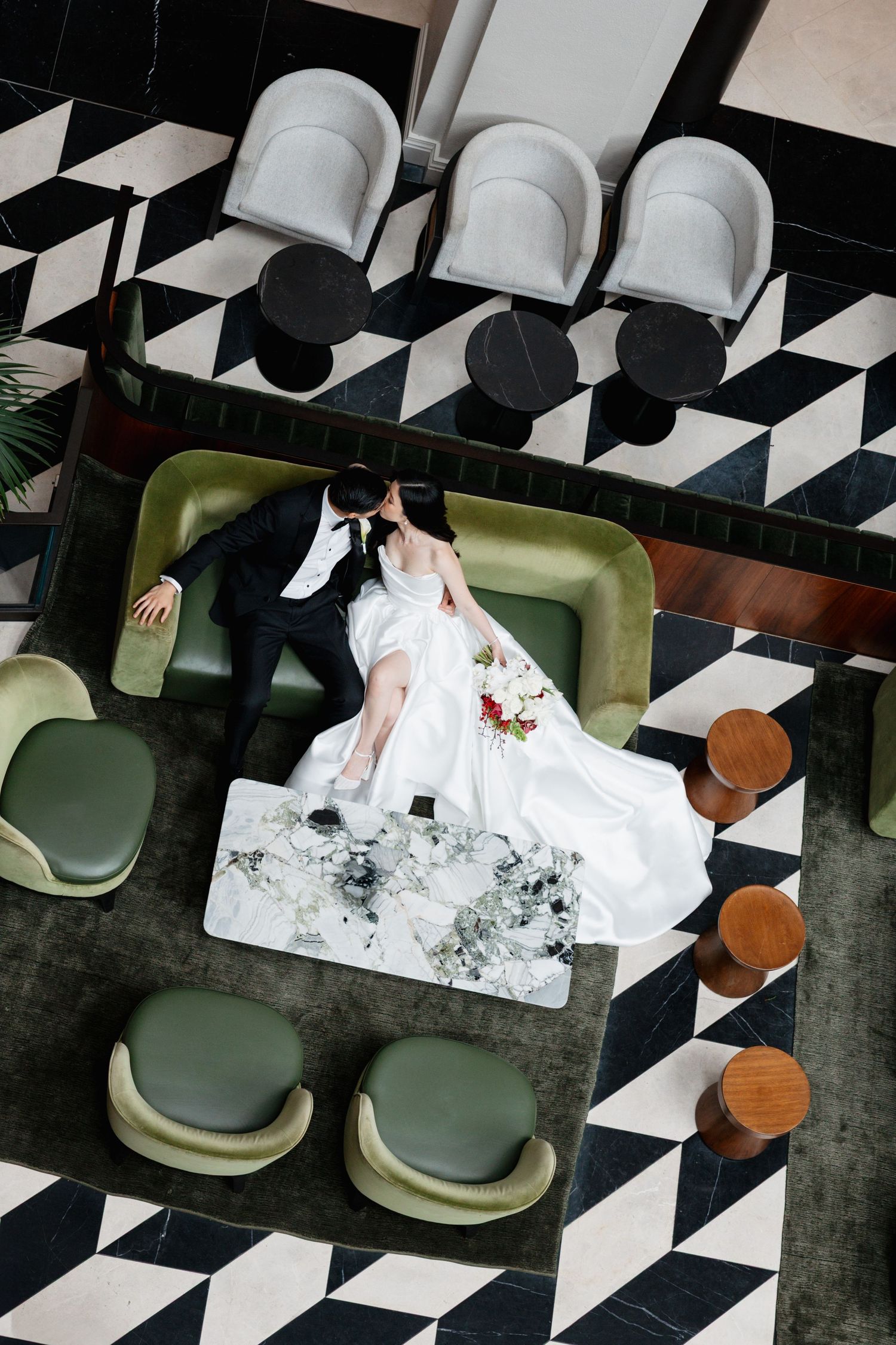 Overhead view of bride in white dress on retro black and white checkered floor.