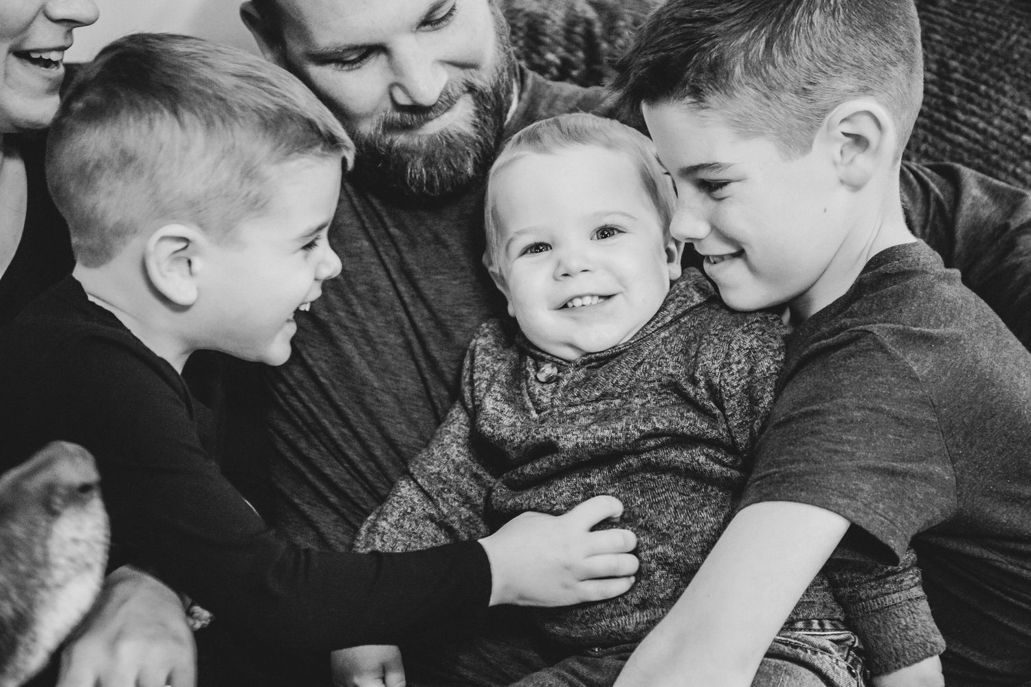 A family hugging and tickling the youngest son