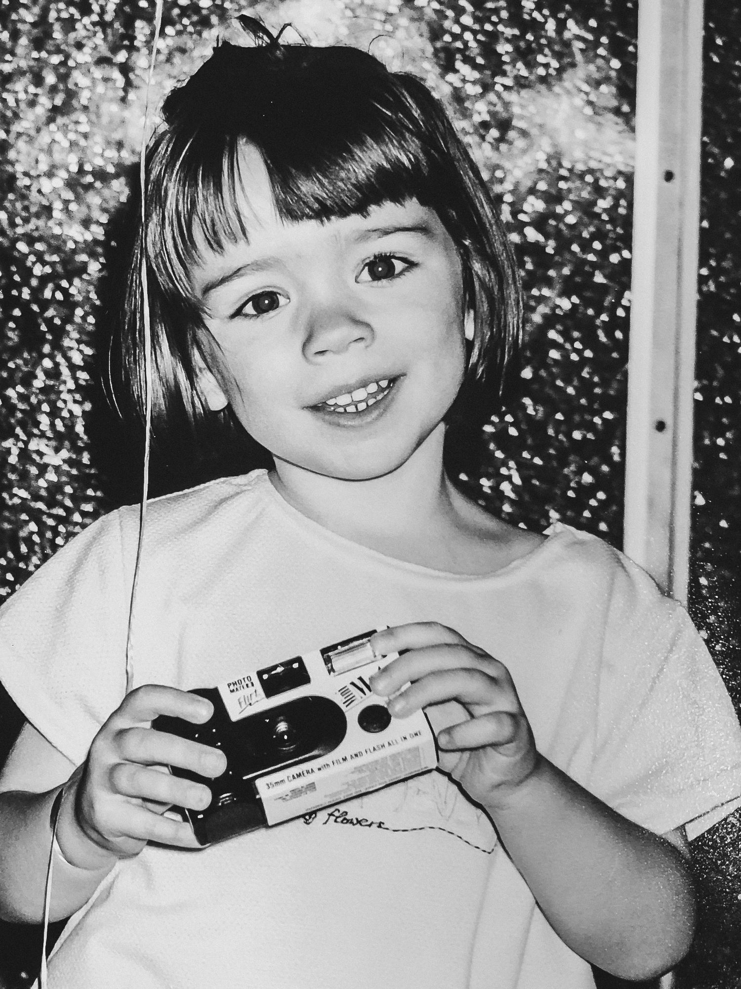 A young Jess holding a disposable camers