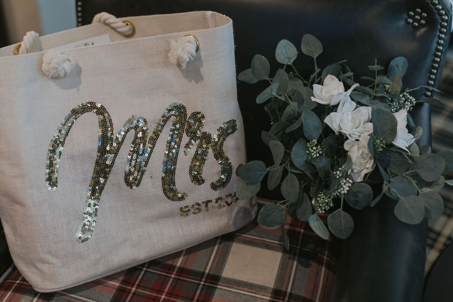 Wedding decor featuring Mrs text with eucalyptus leaves and floral arrangements.