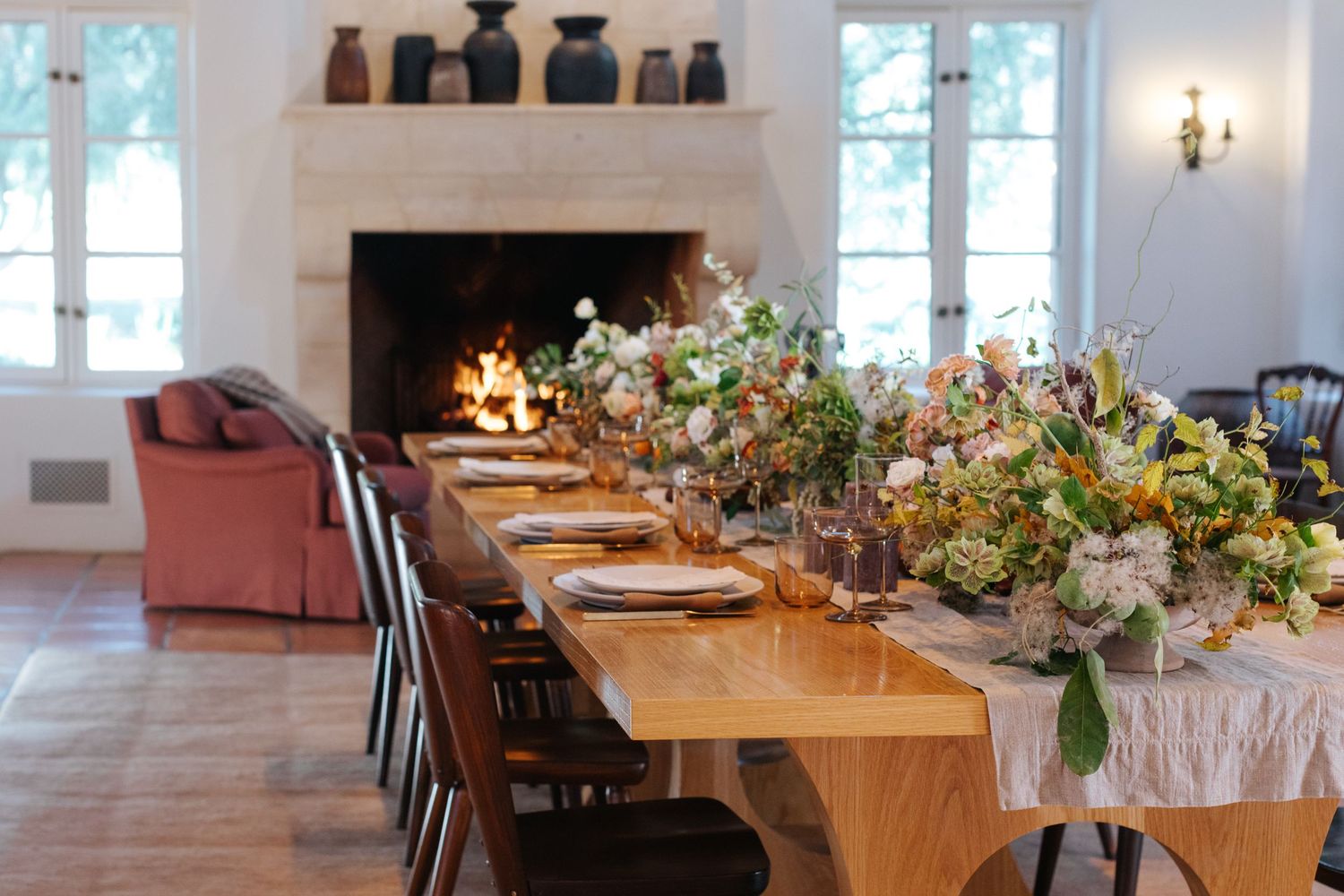 Elegant dining room setup with long wooden tables and floral centerpieces.