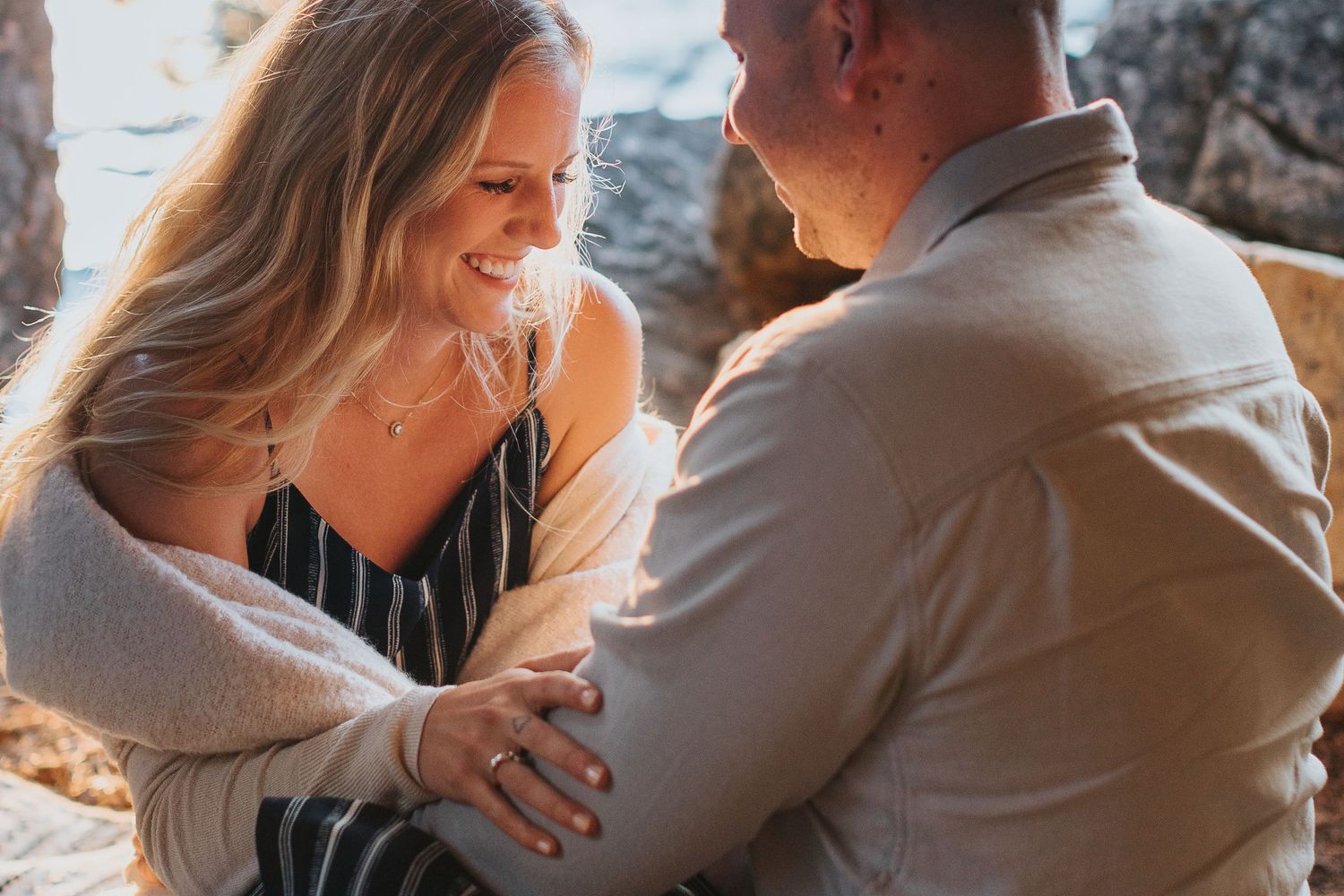 Intimate moment captured between a couple in warm sunlight outdoors.
