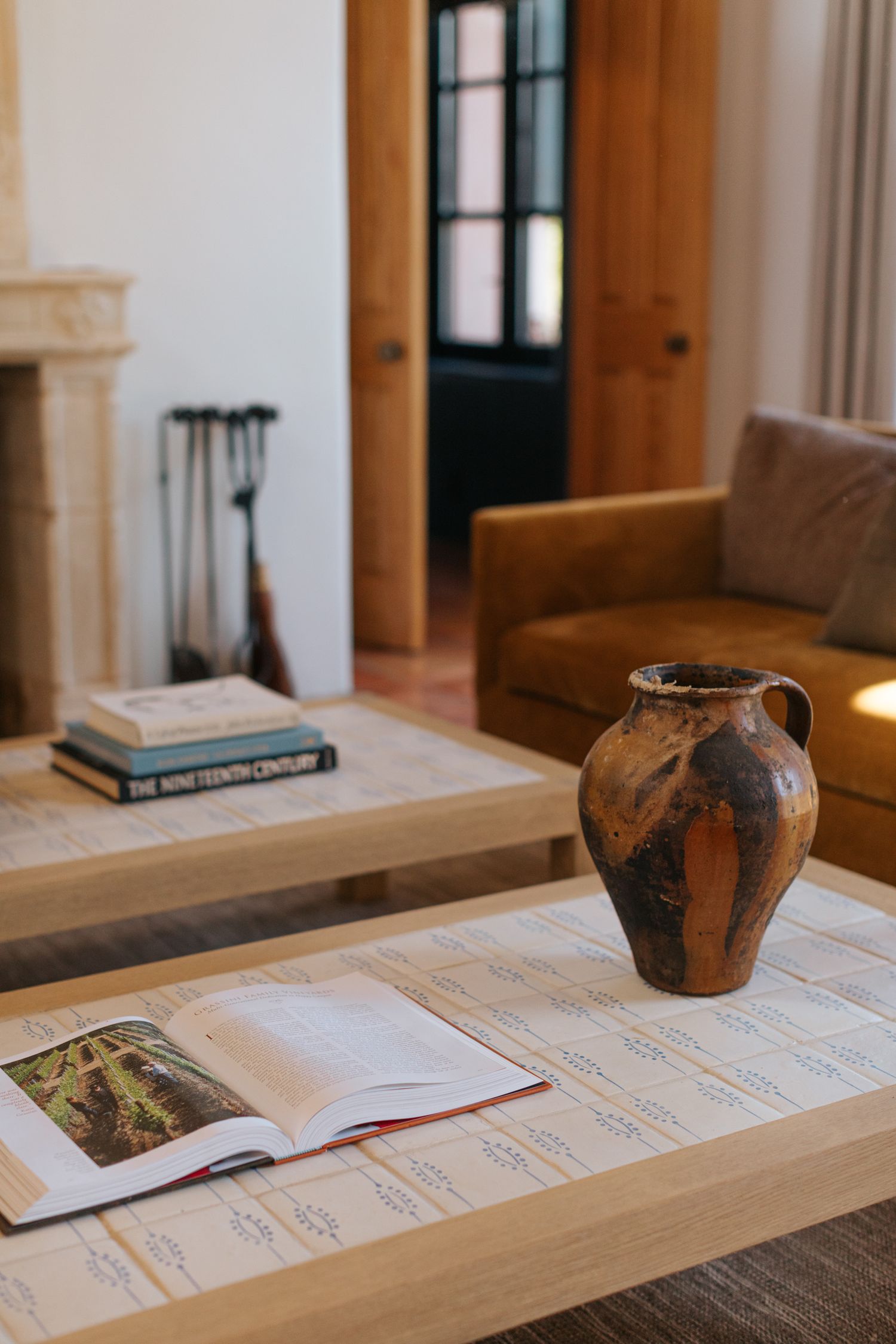Rustic wooden table with vintage pottery and documents in warm interior setting.