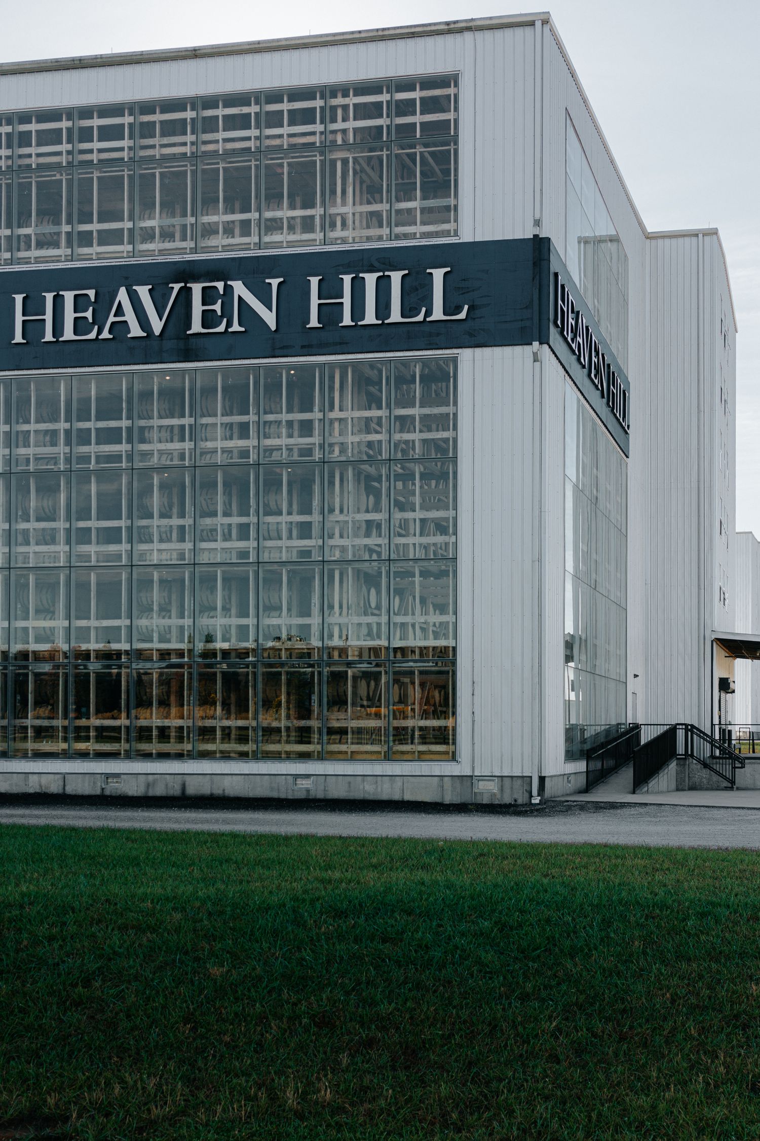Modern white building exterior with glass windows displaying 'Heaven Hill' signage.