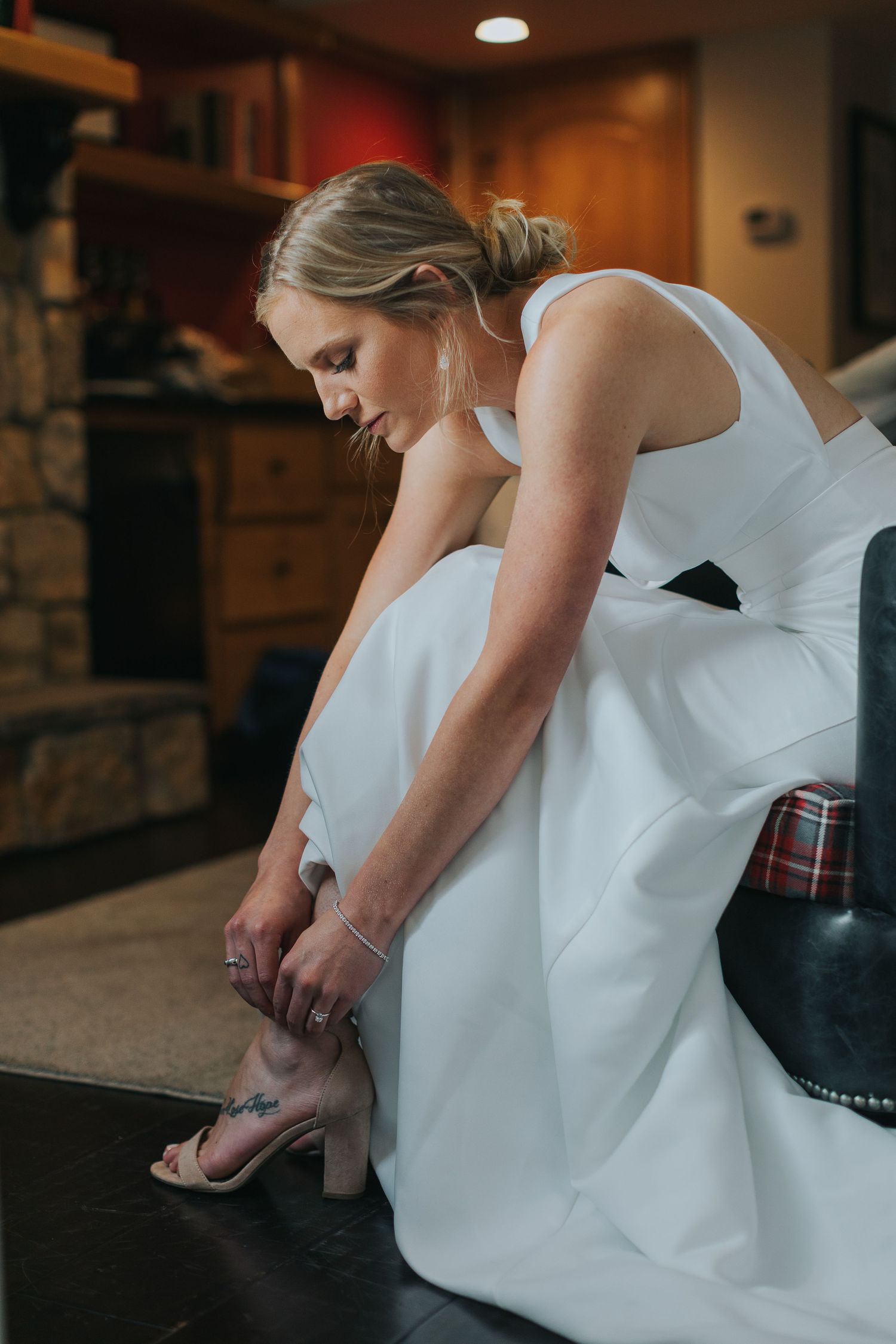 Person in white dress making final adjustments to formal attire.