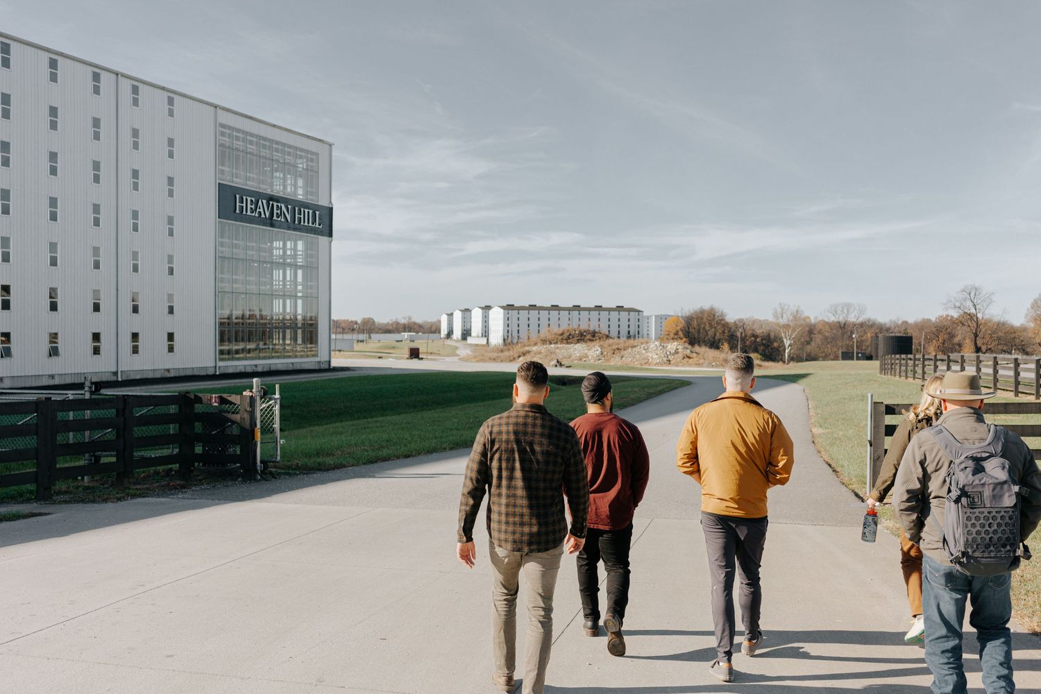 Group walking towards modern Heaven Hill distillery building exterior.