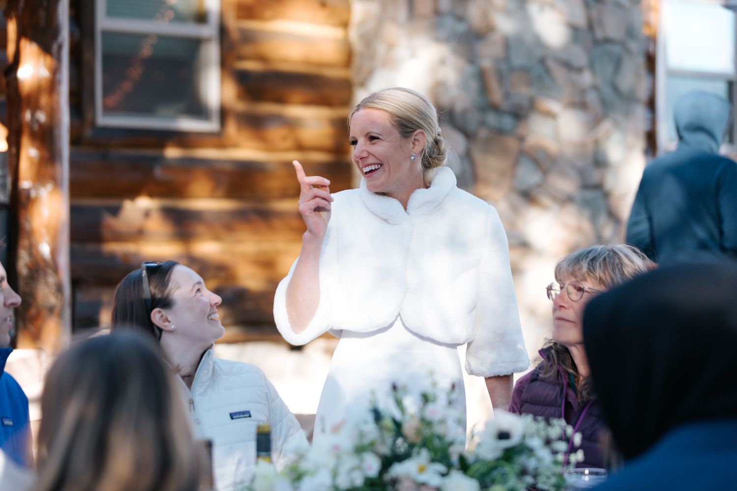 Outdoor wedding celebration at rustic venue with stone and wood architecture.