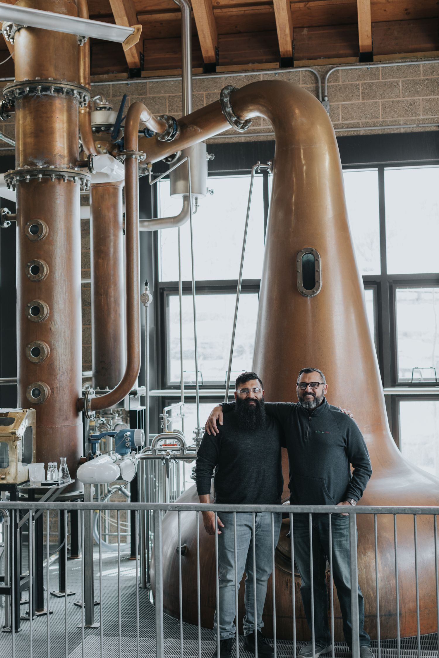 Interior of distillery showing large copper stills and industrial equipment.