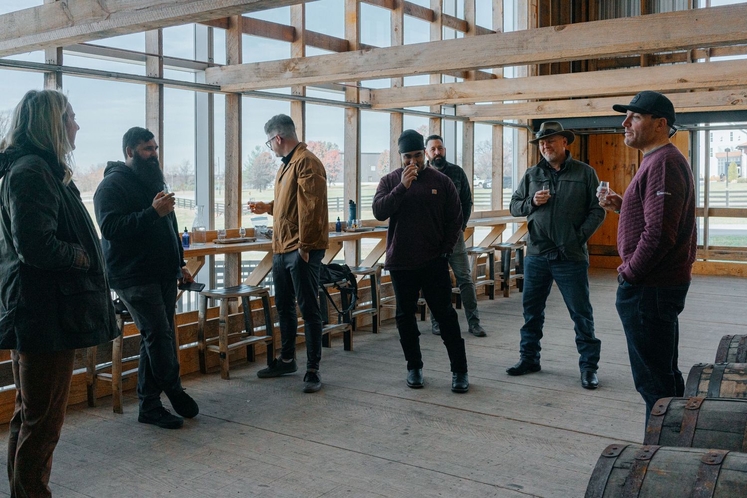 Large group touring a bright, modern distillery warehouse space.